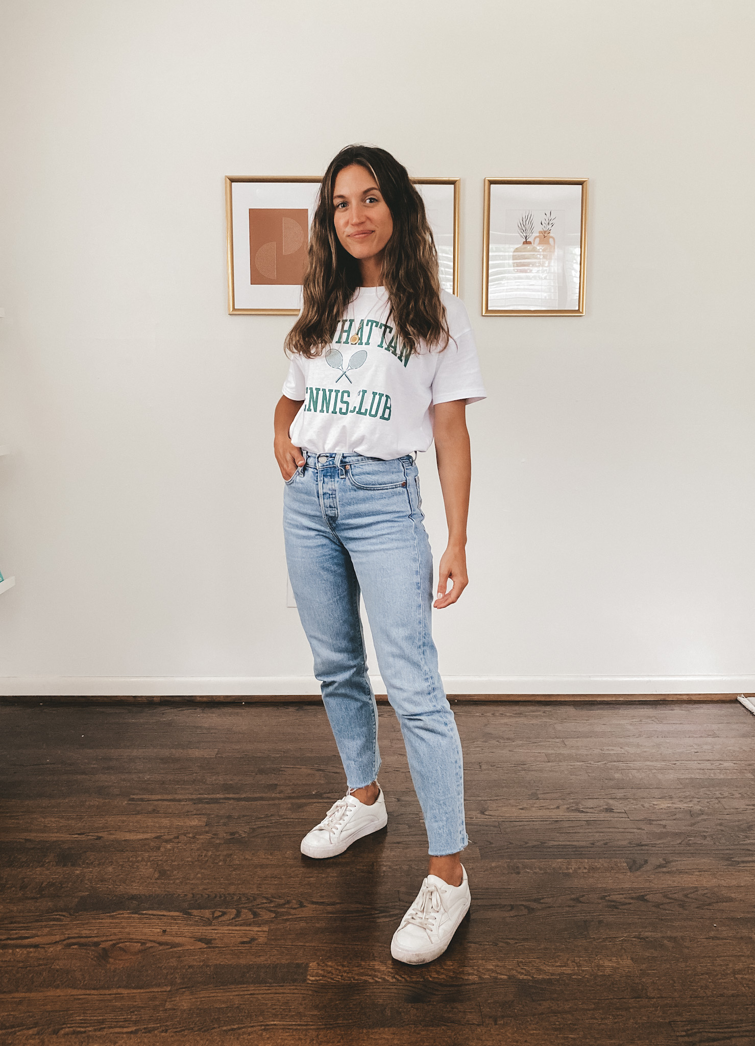 ashley wearing a white oversized graphic tee, light wash mom jeans and white sneakers