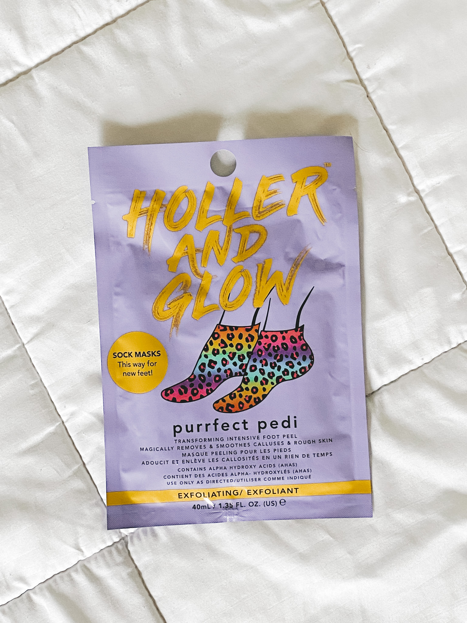 a Holler and Glow Purrfect Pedi Foot Peel on a white blanket