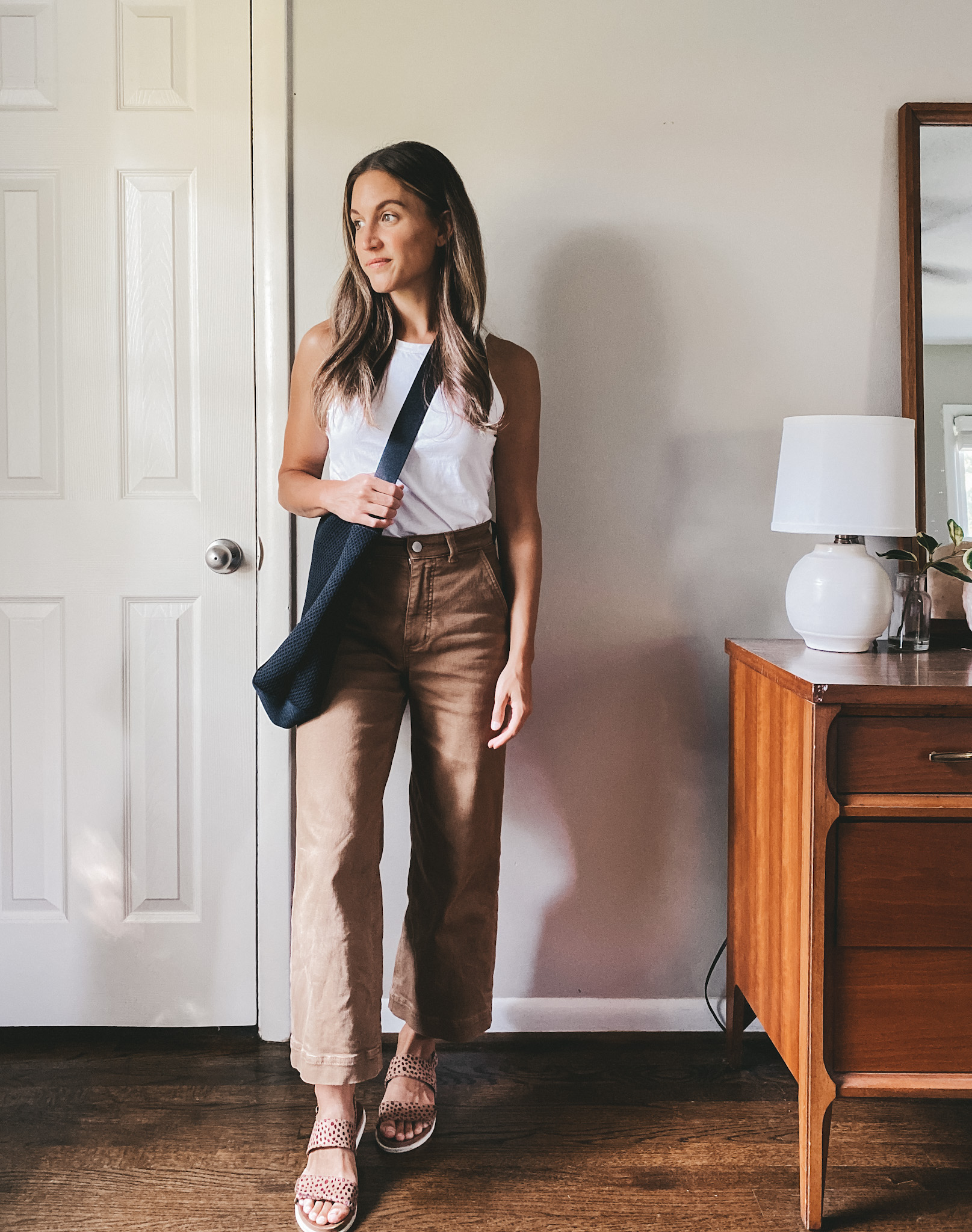 ashley wearing a white tank, brown wide leg cropped pants, leopard print sandals and a black tote bag; early fall outfit