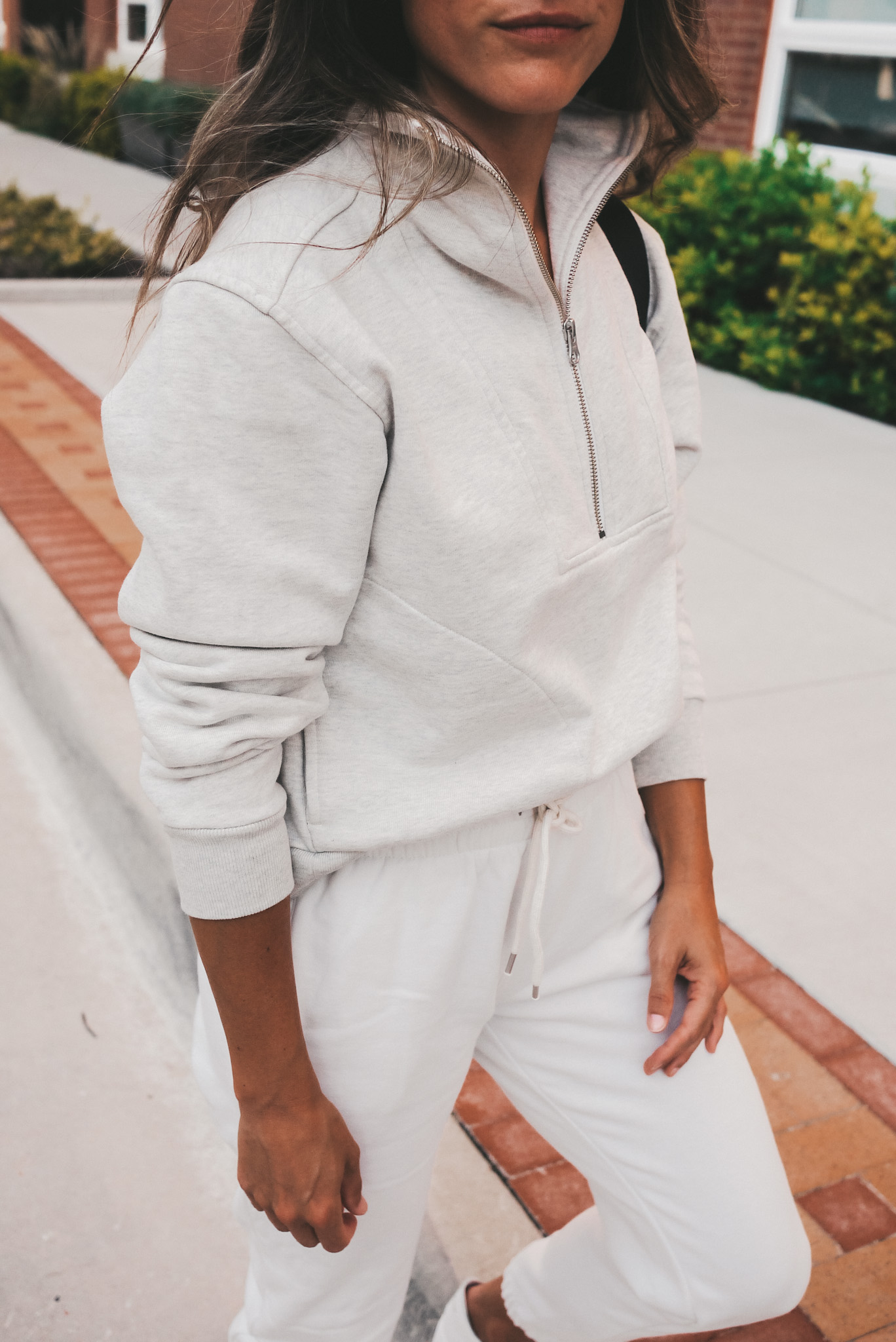 ashley wearing a track half zip sweatshirt from Everlane and white Gap joggers