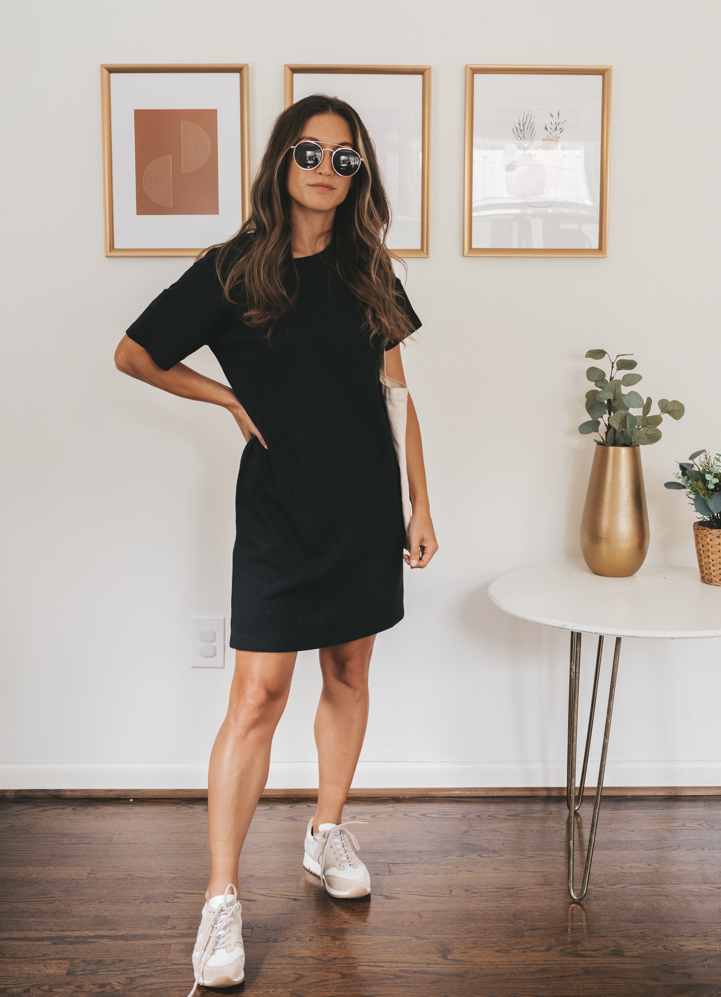 ashley wearing a black t-shirt dress, white and tan leather sneakers, and a canvas tote bag