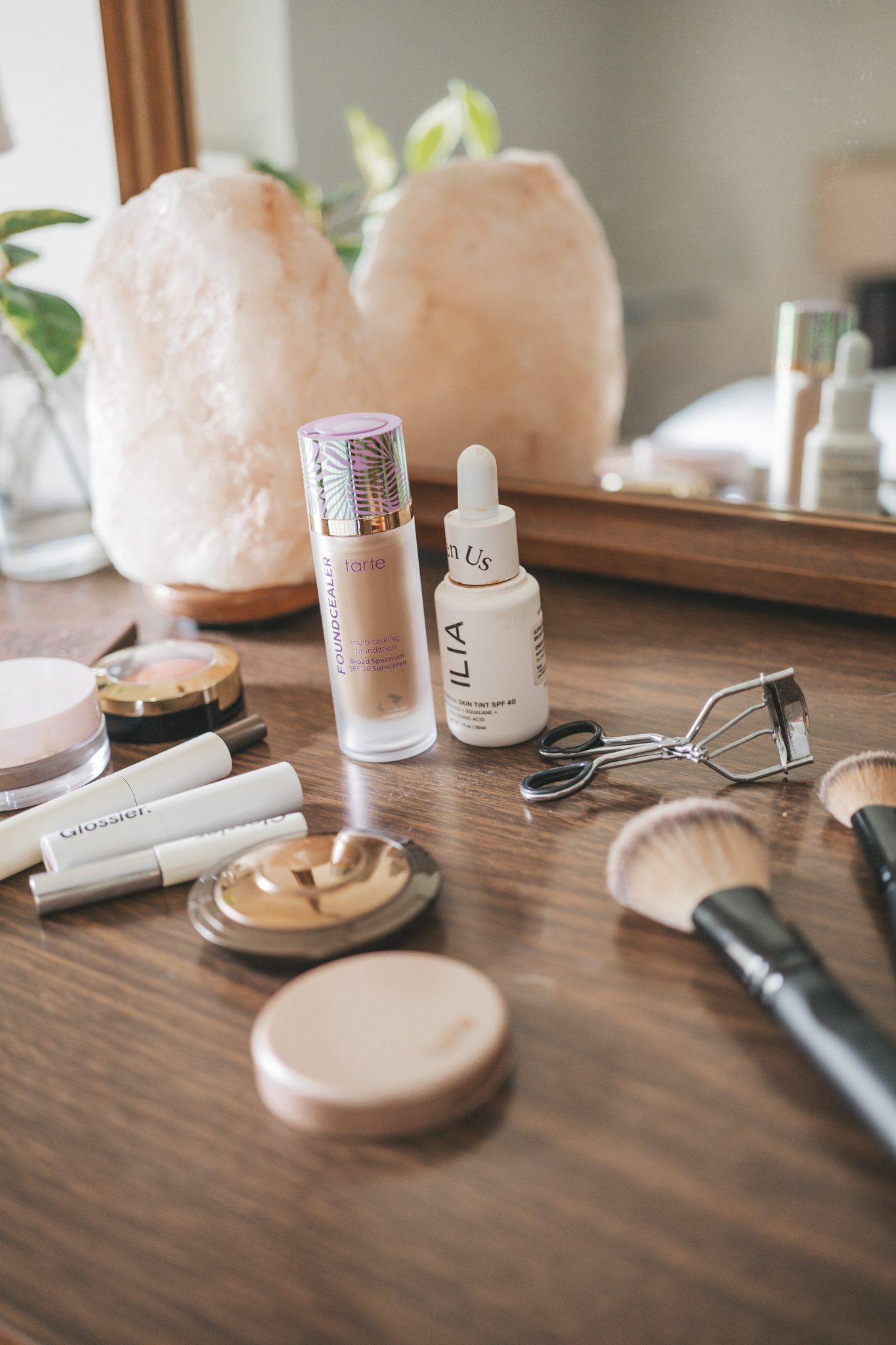 make-up products laid out on a wood dresser