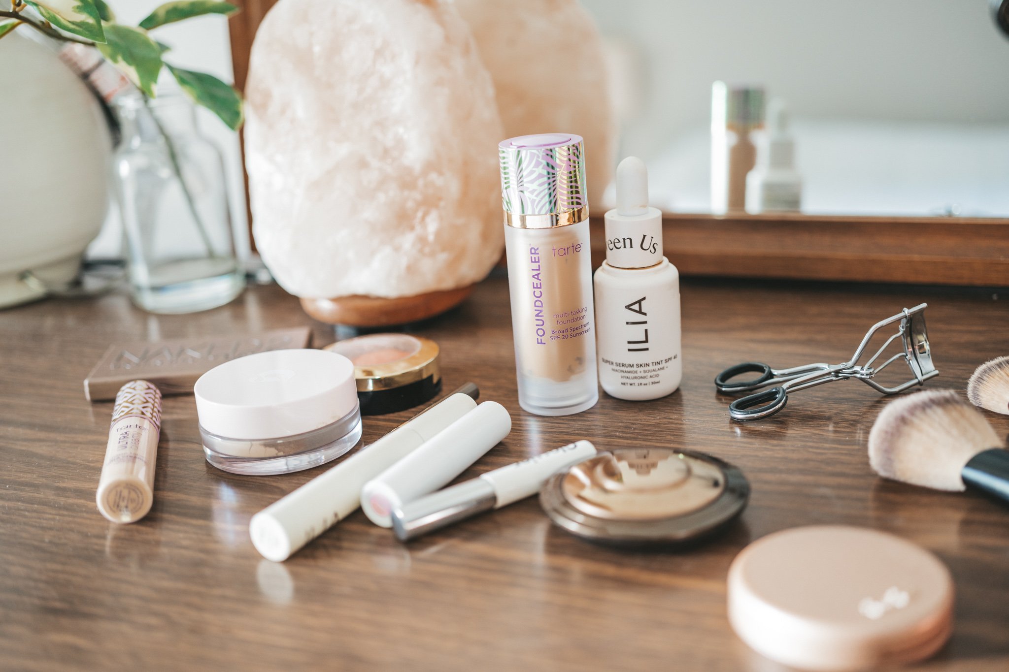 make-up products laid out on a wood dresser