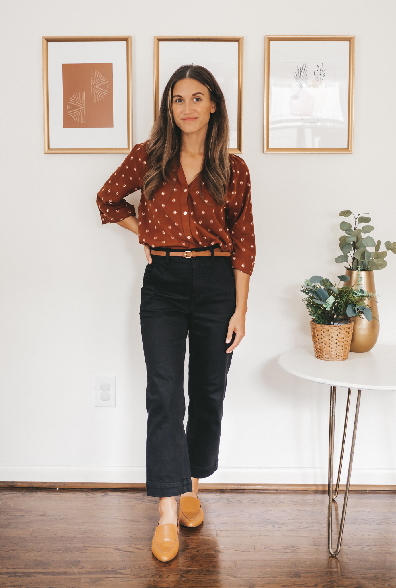 ashley wearing a rust colored peasant blouse, black cropped pants, and brown loafers