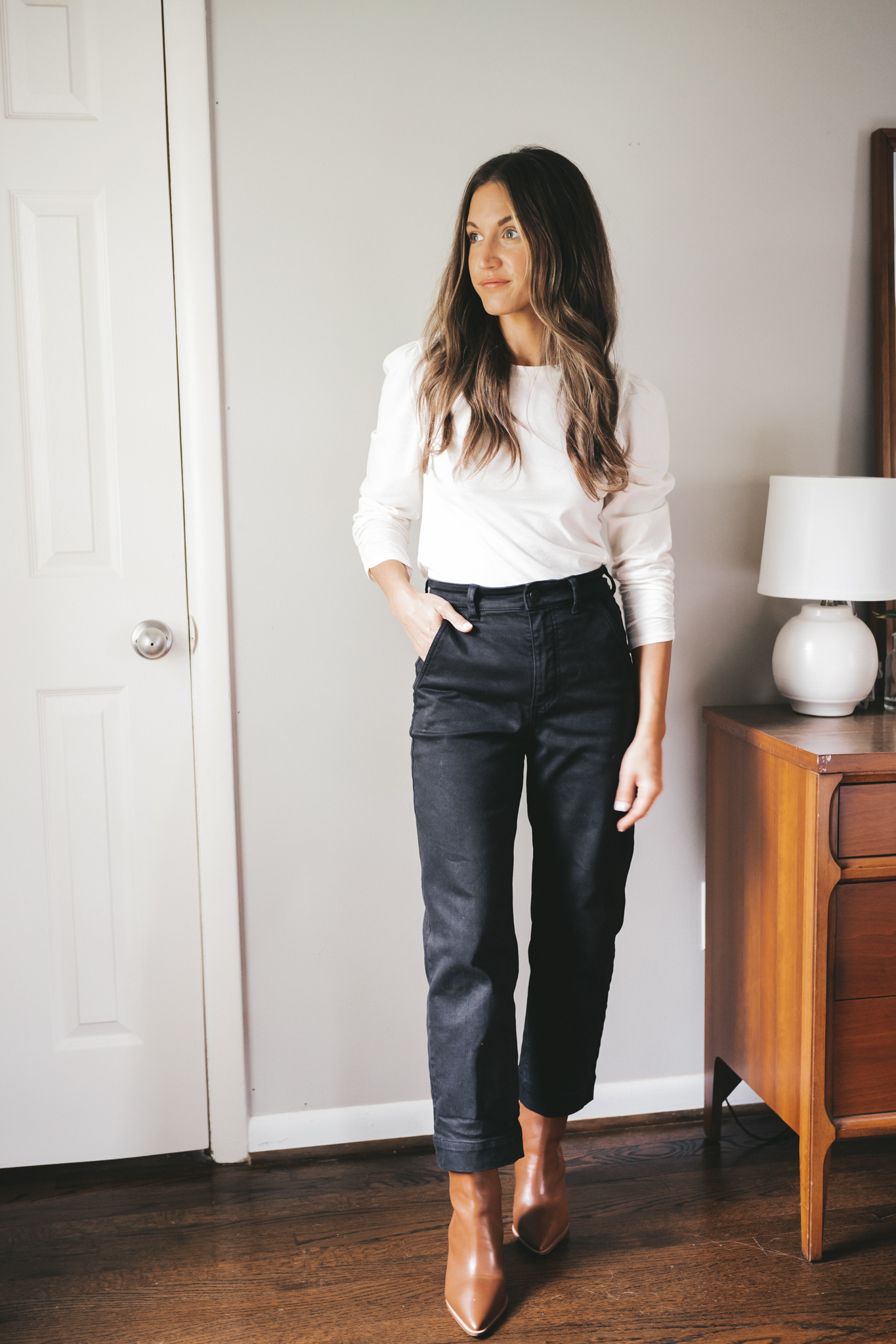 autumn look from my capsule wardrobe; ashley wearing a white puff sleeve top, black cropped pants, and cognac heeled ankle boots
