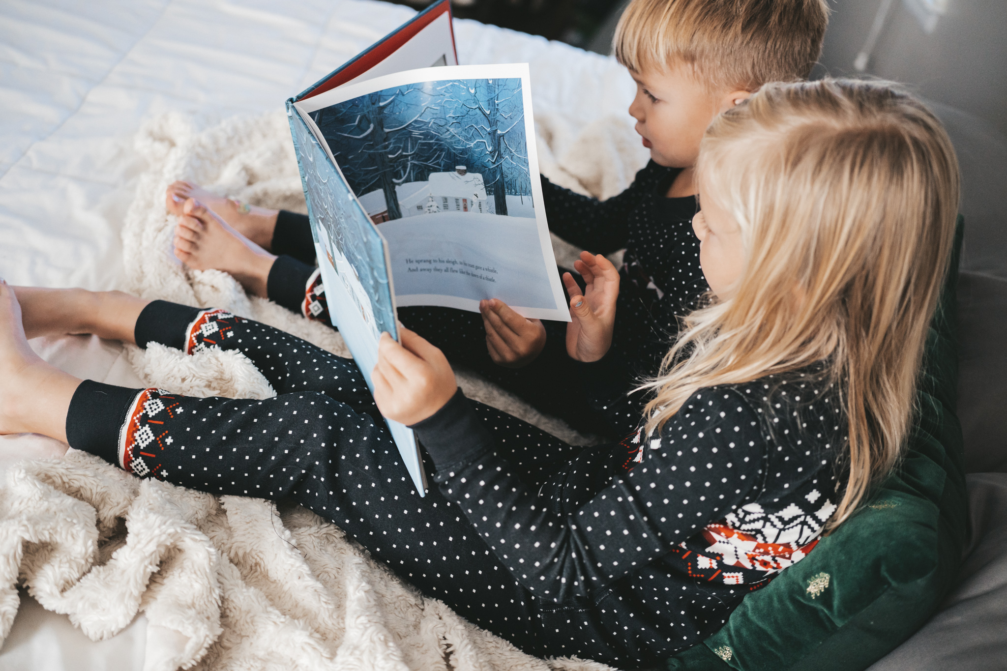 two kids in pajamas reading The Night Before Christmas