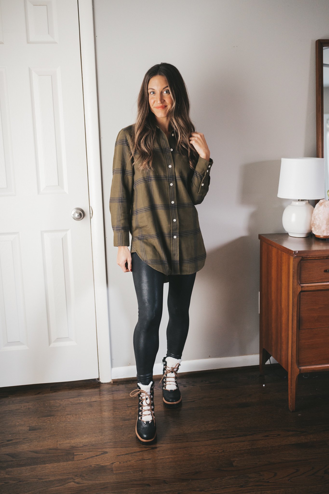 ashley wearing a green and black plaid flannel, faux leather leggings, and black lace up sherpa boots