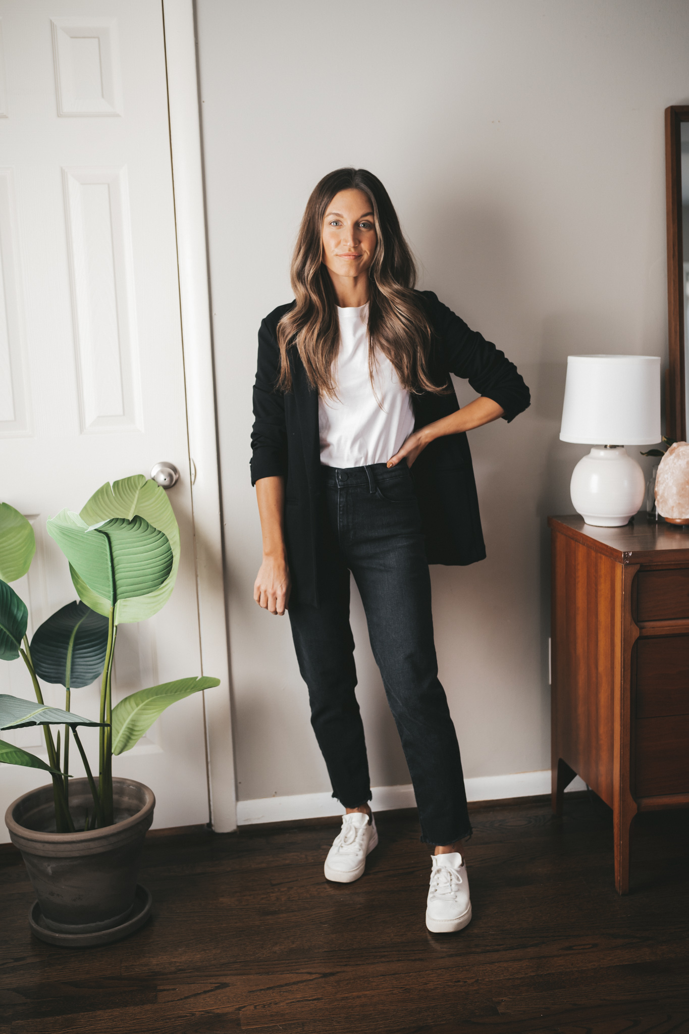 ashley wearing a white tee, black blazer, black denim, and white sneakers