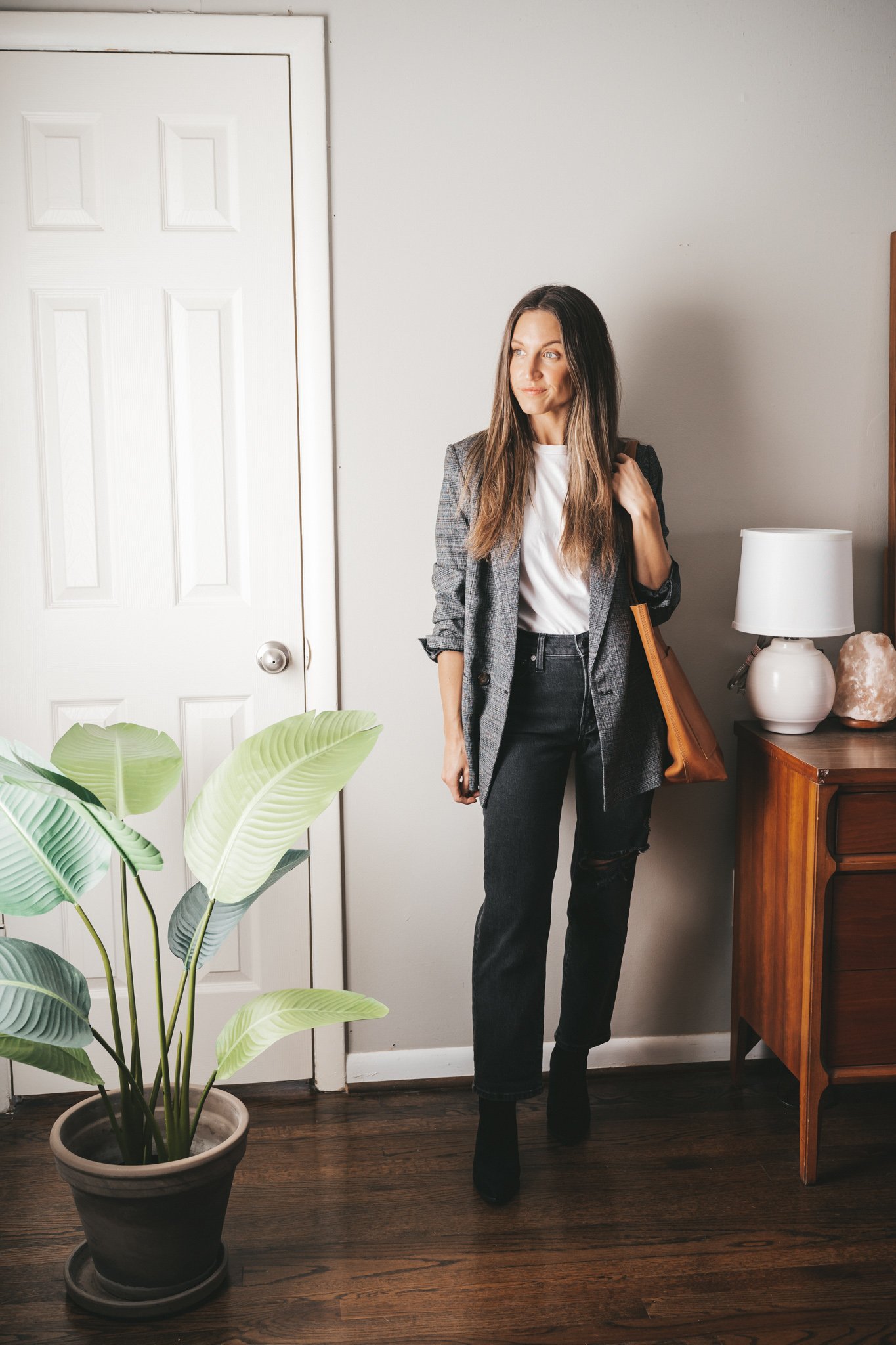 winter outfit idea with a white tee, gray plaid oversized blazer, black distressed straight denim, and black suede heeled ankle boots