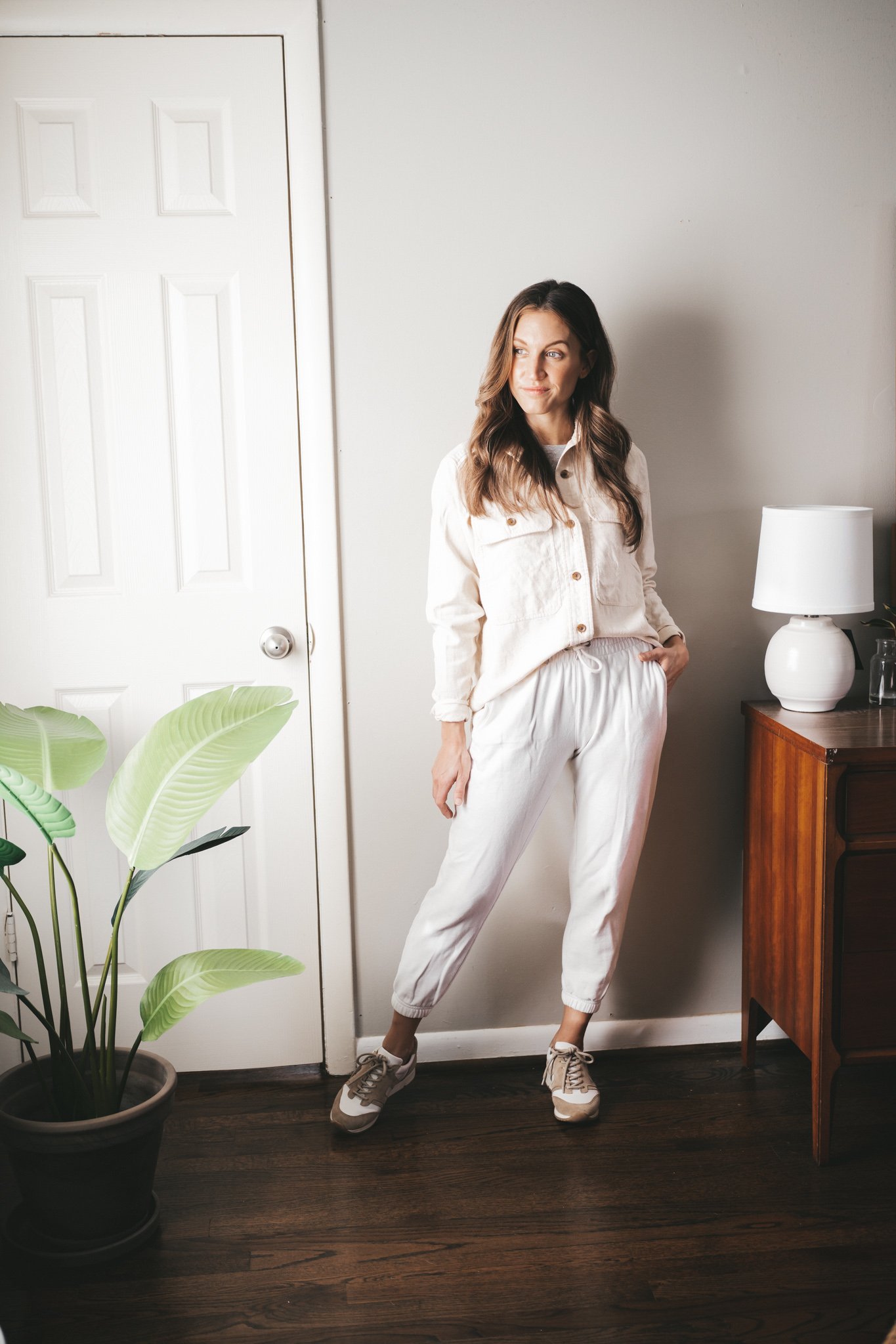 winter capsule wardrobe outfit idea with a cream colored flannel, white joggers, and white and tan leather sneakers