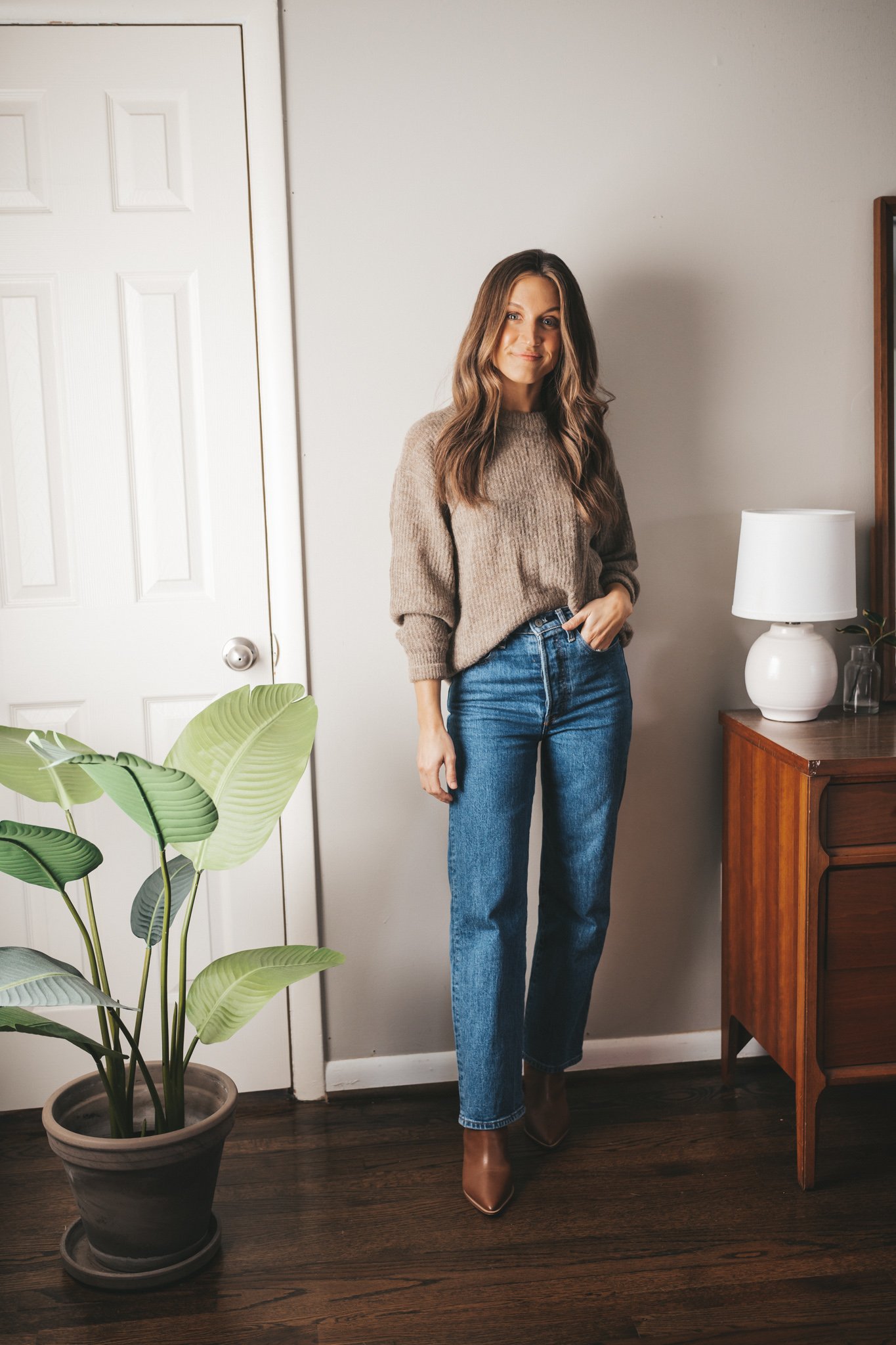 winter capsule wardrobe Everlane Oversized Alpaca sweater in clay worn with mid-wash straight leg denim and brown heeled ankle boots