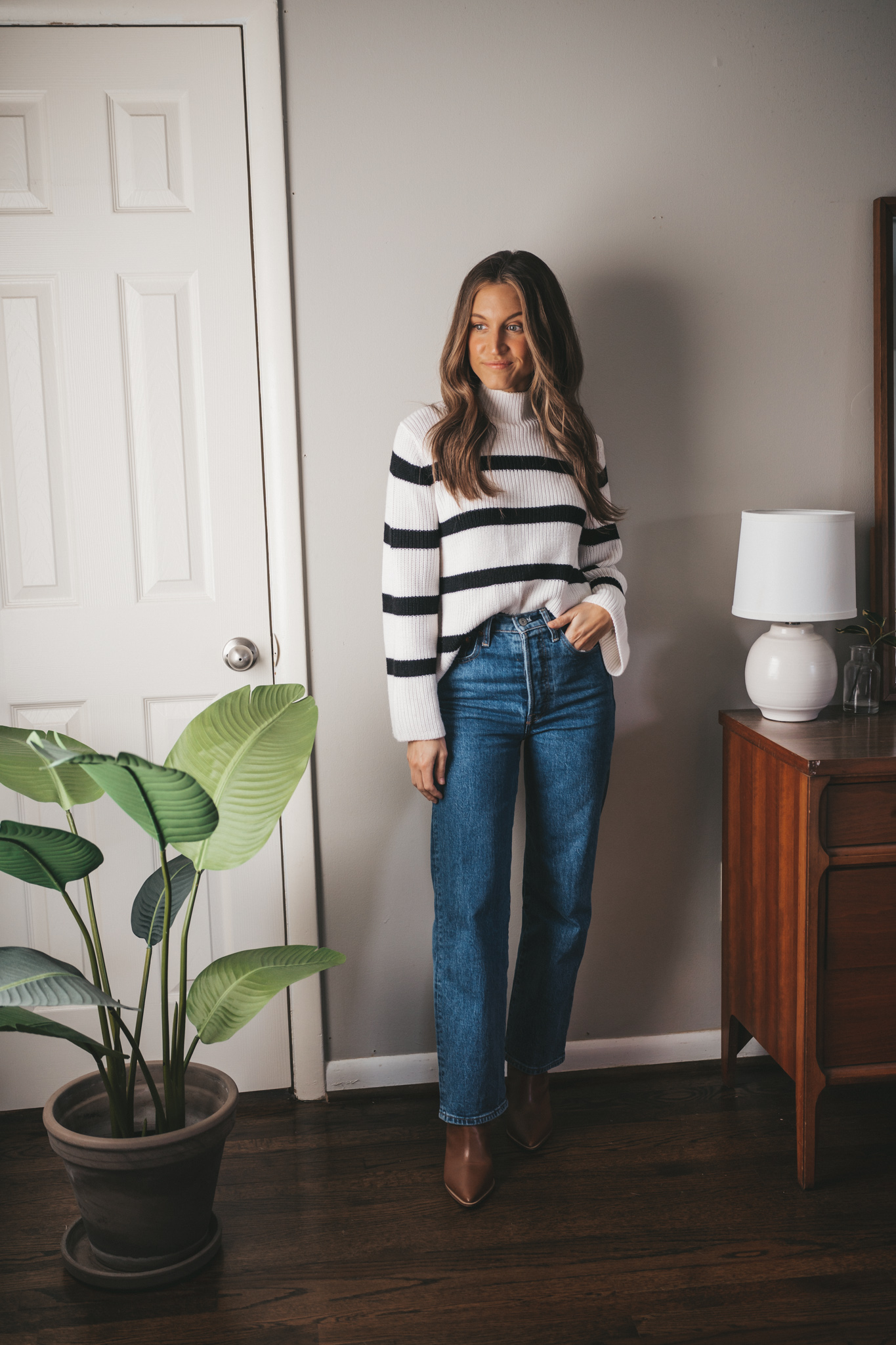 winter capsule wardrobe striped sweater worn with straight leg denim and brown ankle boots