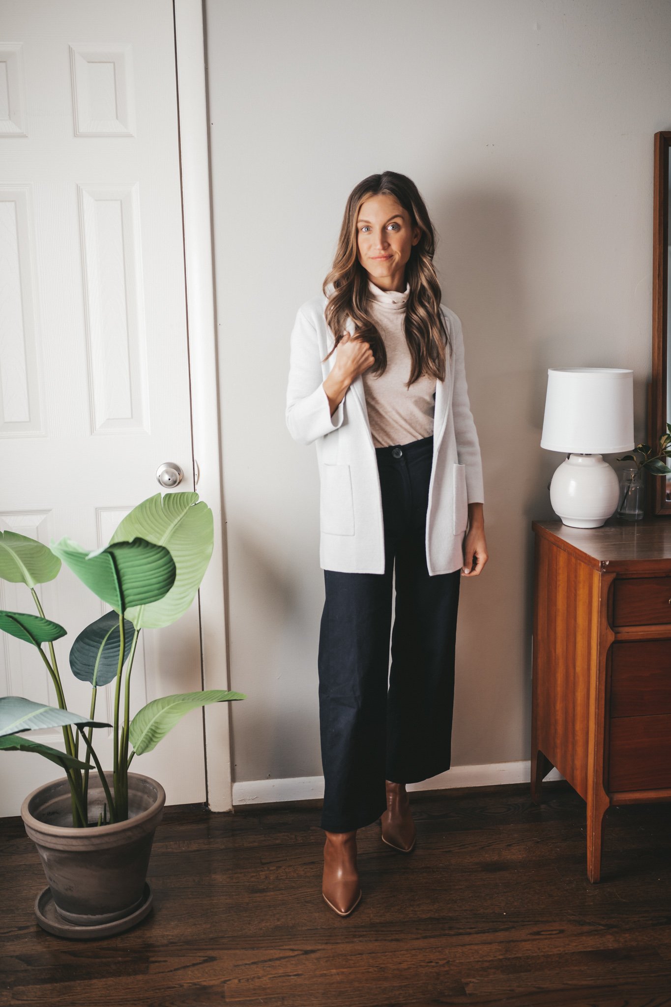 winter outfit with an ivory turtleneck, gray sweater blazer, black pants, and brown ankle boots
