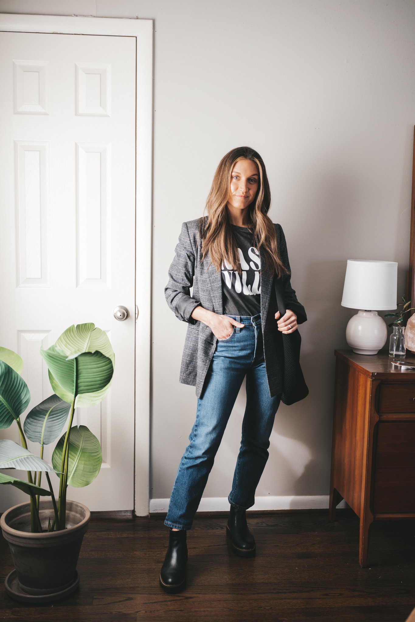 blazer outfit with a gray plaid blazer, graphic tee, mid-wash straight denim, and black lug-sole Chelsea boots with a black mesh tote bag
