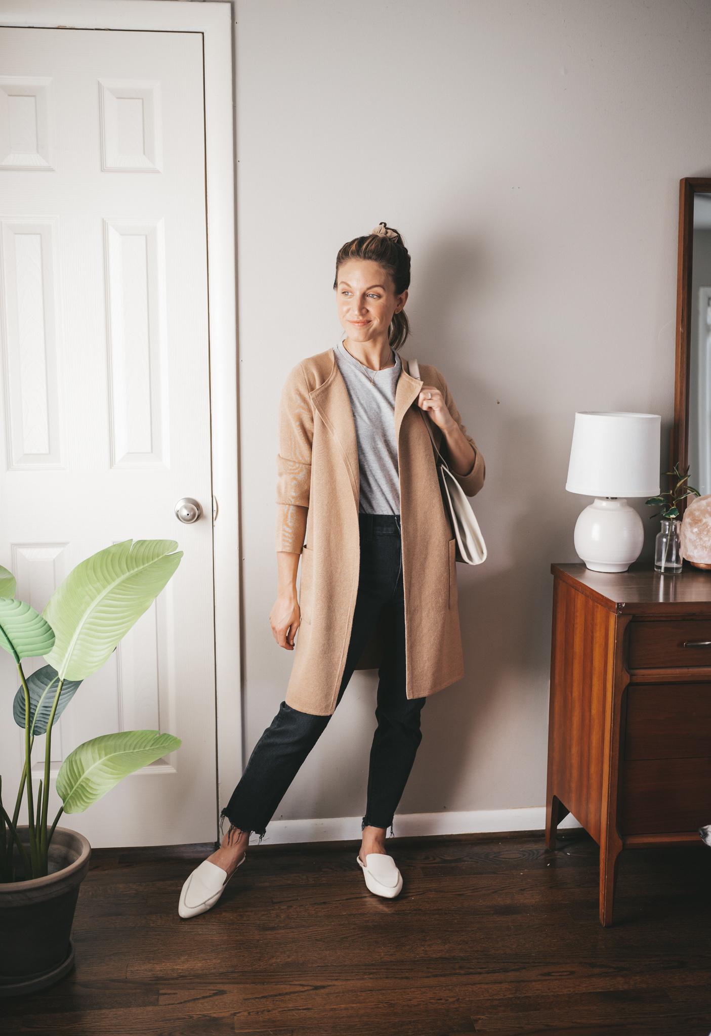 spring outfit idea with a gray tee, long line sweater blazer, black denim, and white mules