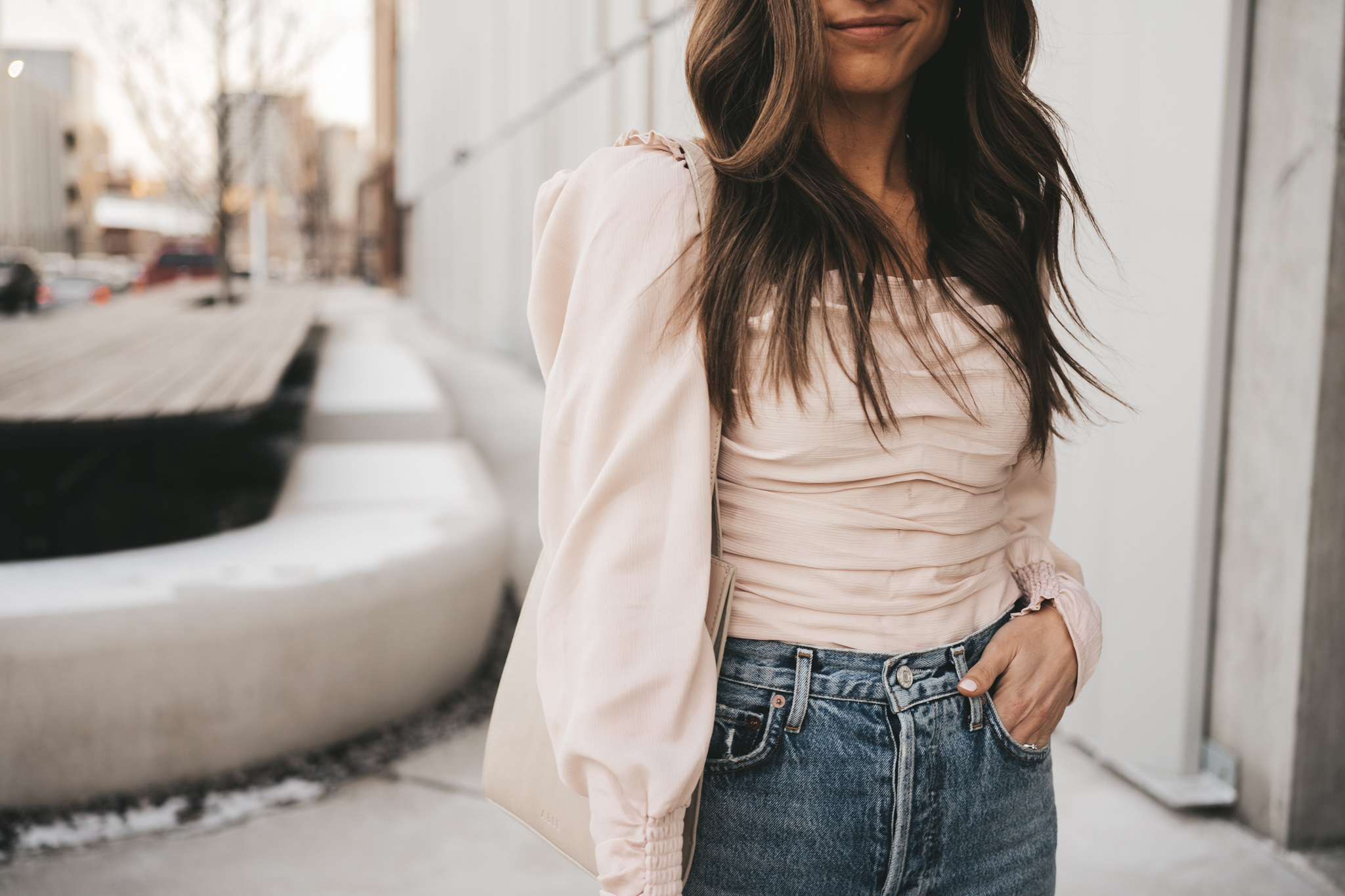 spring date night outfit with a blush ruched front top, distressed denim, and taupe heeled sandals