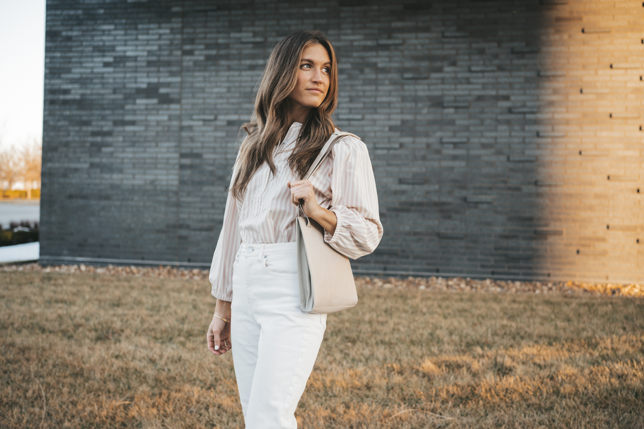 spring outfit with a striped blouse, white denim, and nude block heel sandals