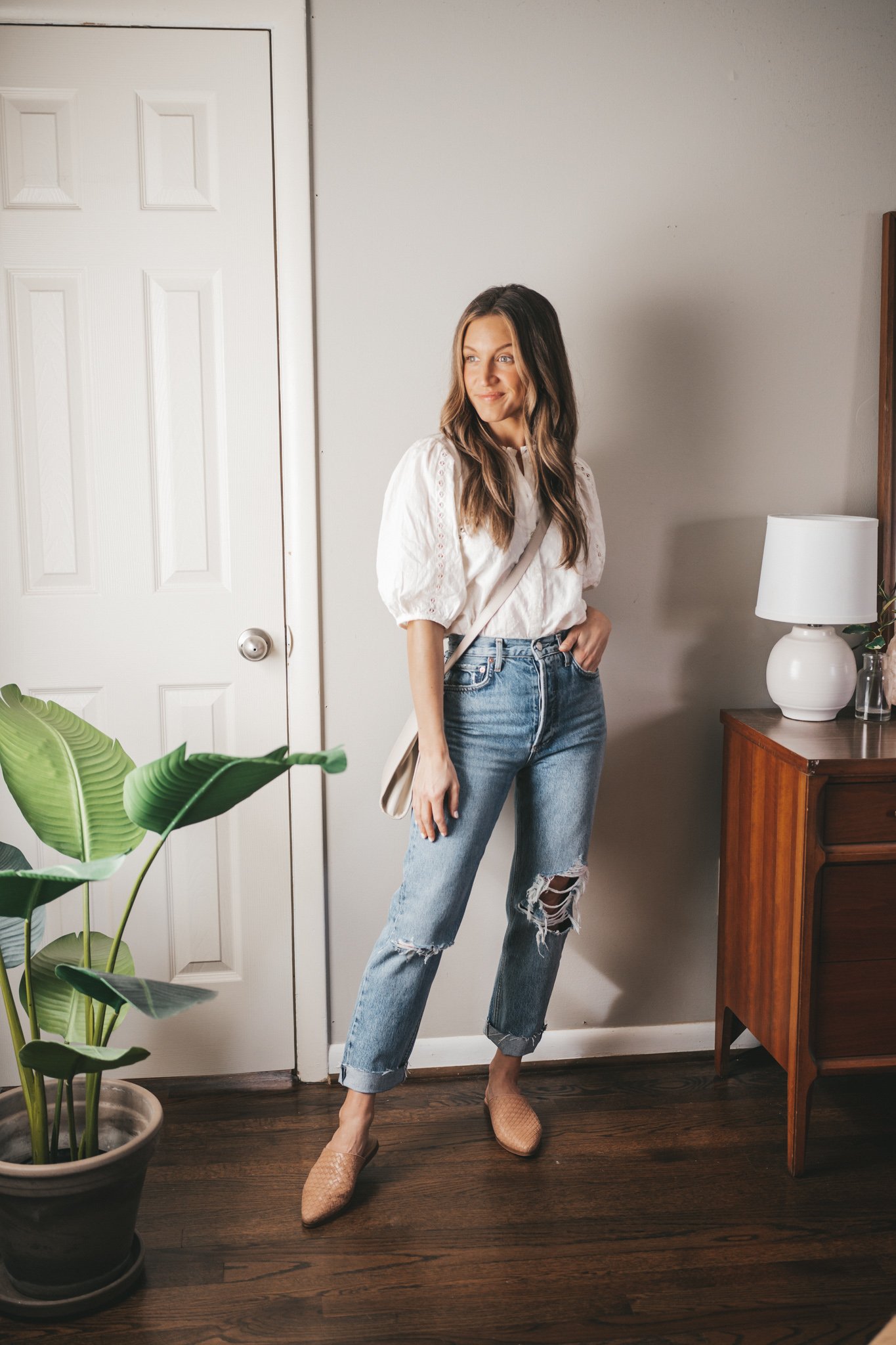 outfit from my spring capsule wardrobe - white lace detail blouse, distressed denim, nude woven mules, and a gray crossbody bag