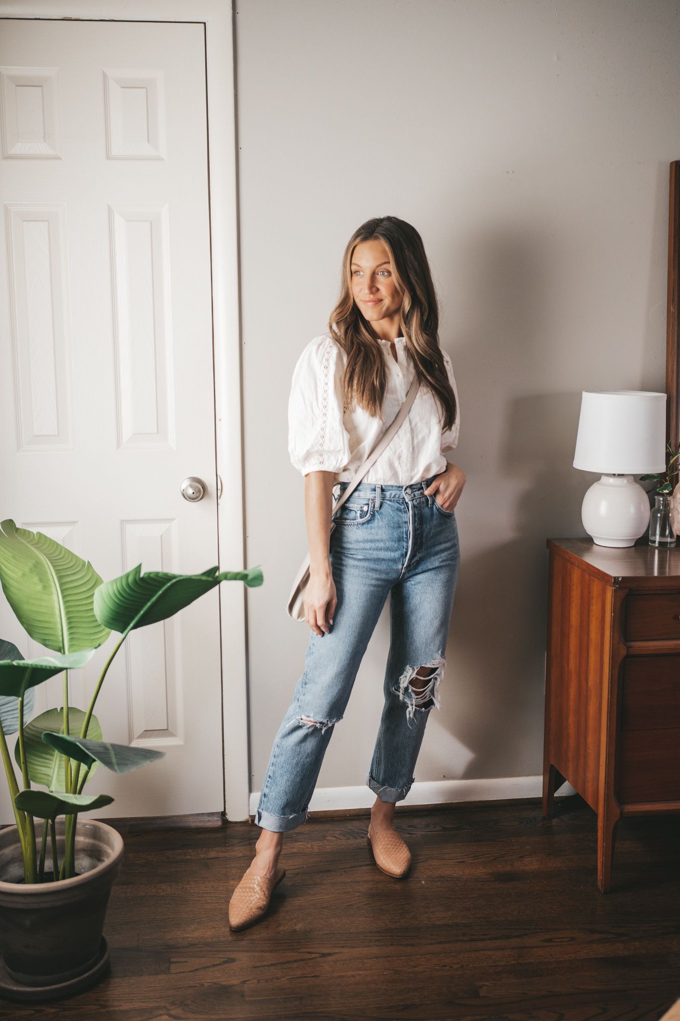 outfit from my spring capsule wardrobe - white lace detail blouse, distressed denim, nude woven mules, and a gray crossbody bag