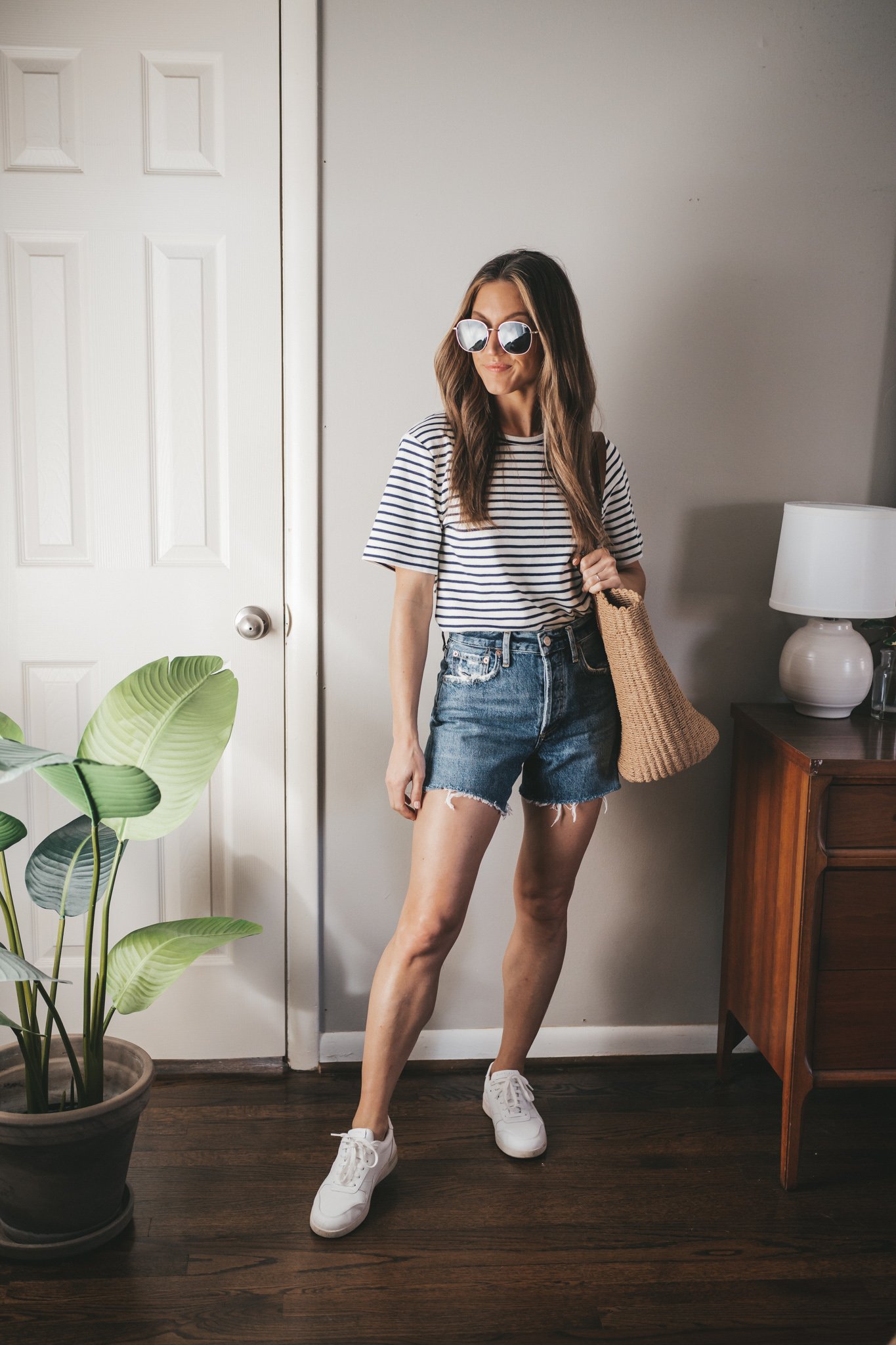 spring break outfit with a striped tee, denim cut-off shorts, and white sneakers