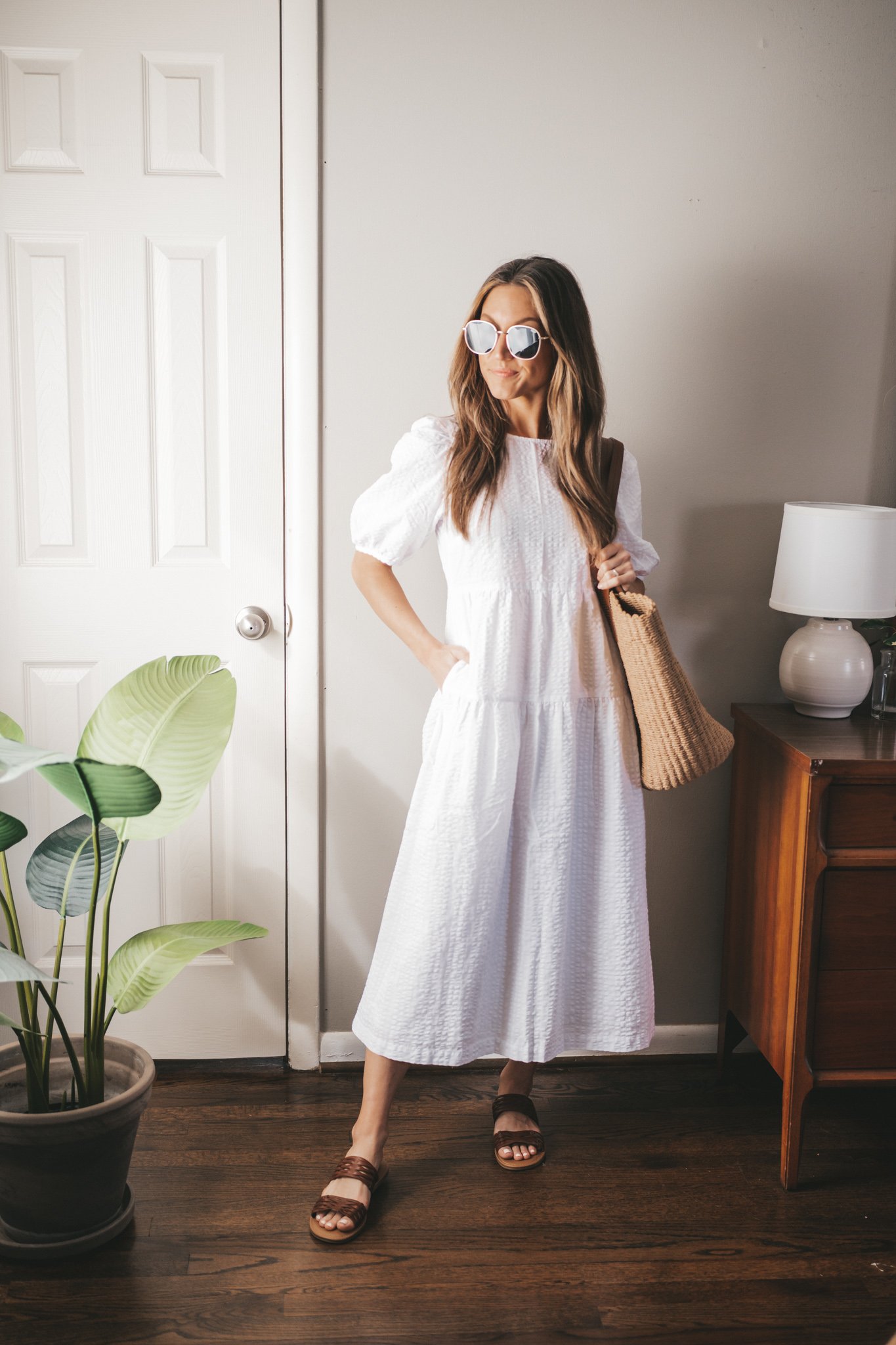 spring break outfit with with a white midi dress, braided sandals, and a straw tote bag