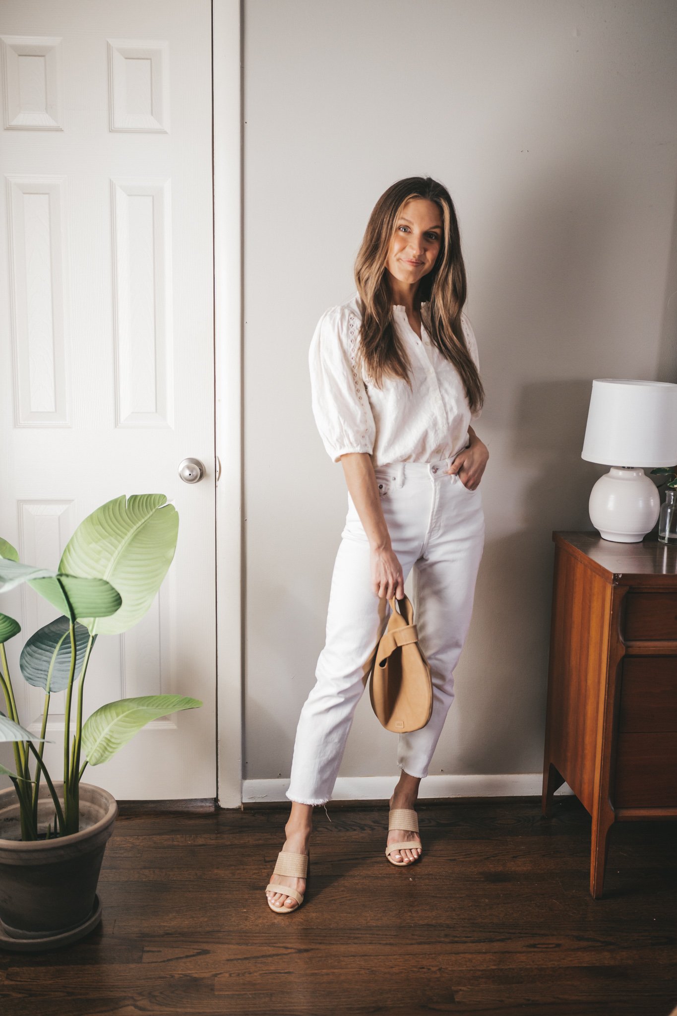 spring break outfit with a white blouse, white denim, and heeled straw sandals