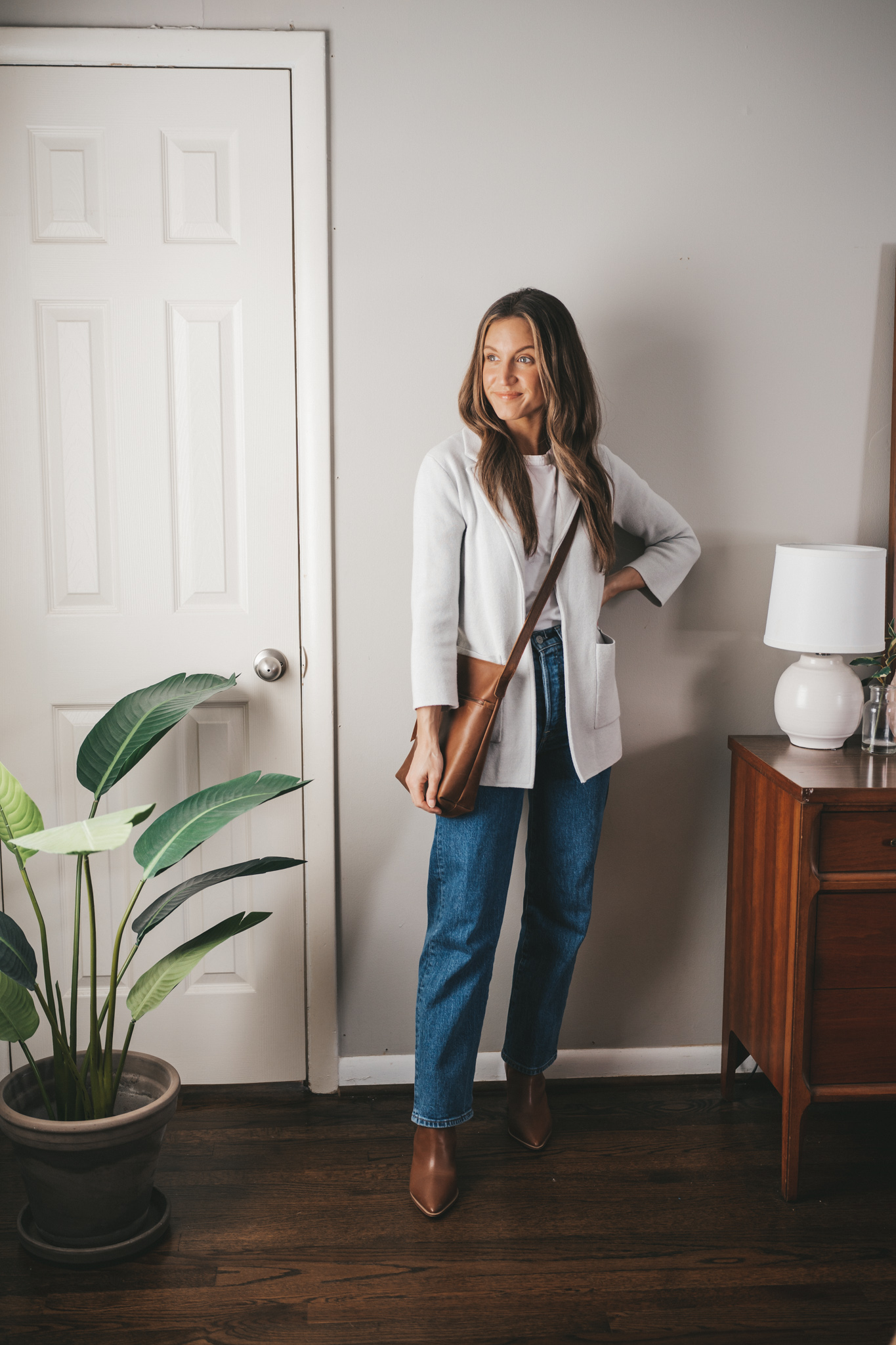 spring capsule wardrobe outfit with a white tee, gray sweater blazer, straight denim and brown boots