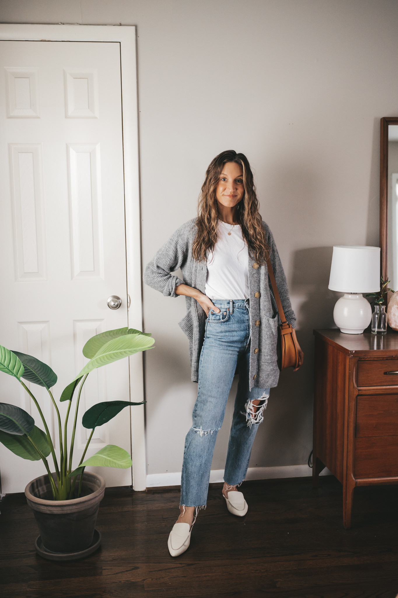 spring outfit with a white tee, gray cardigan, distressed denim, white mules and a cognac crossbody bag