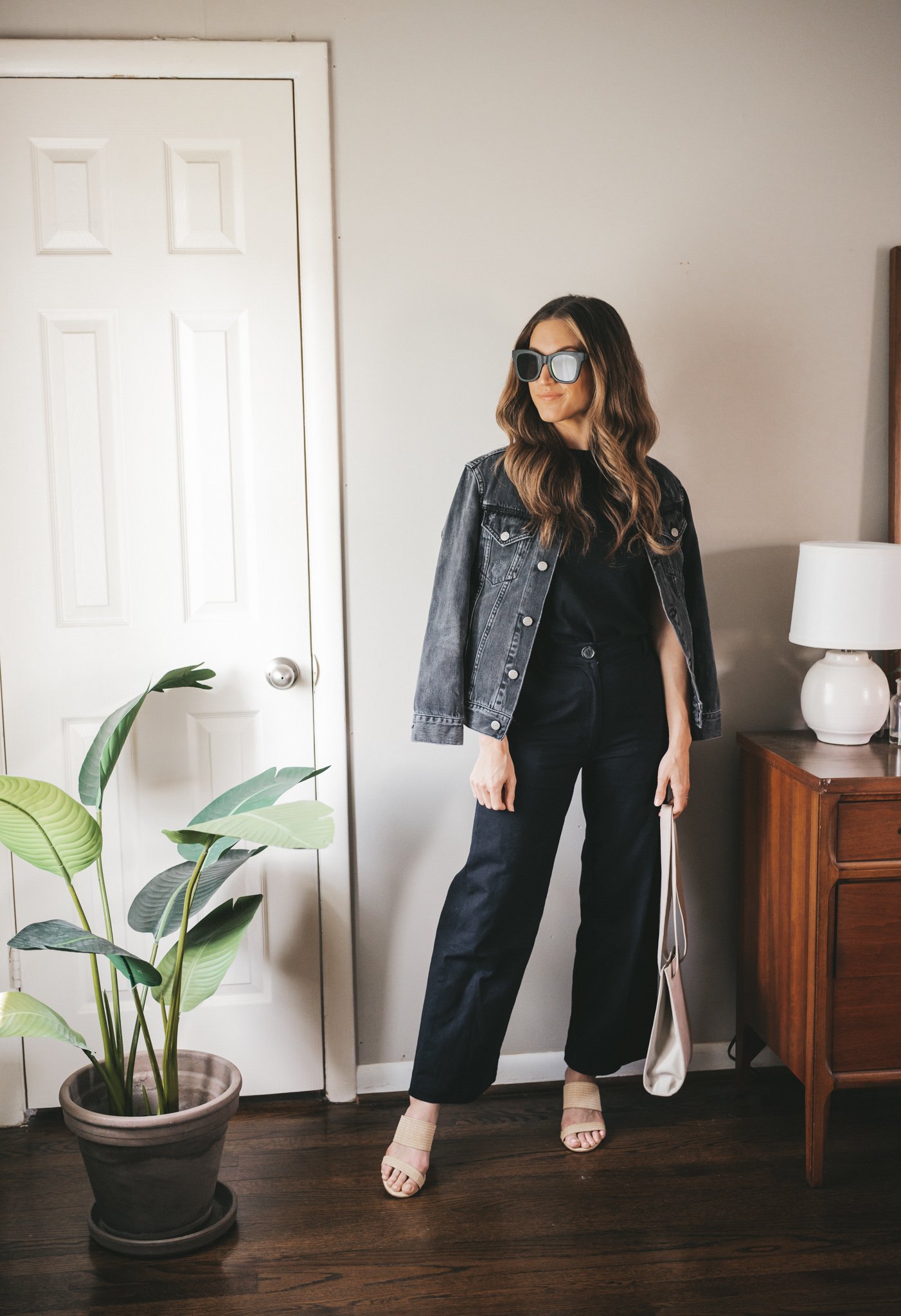 outfit for spring with a black tee, black denim jacket, black wide leg pants, and woven heeled sandals
