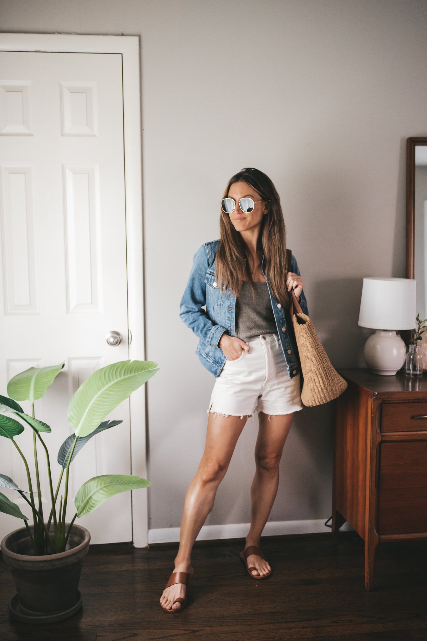 outfit for spring with a taupe sweater tank, white denim, denim jacket, and brown sandals