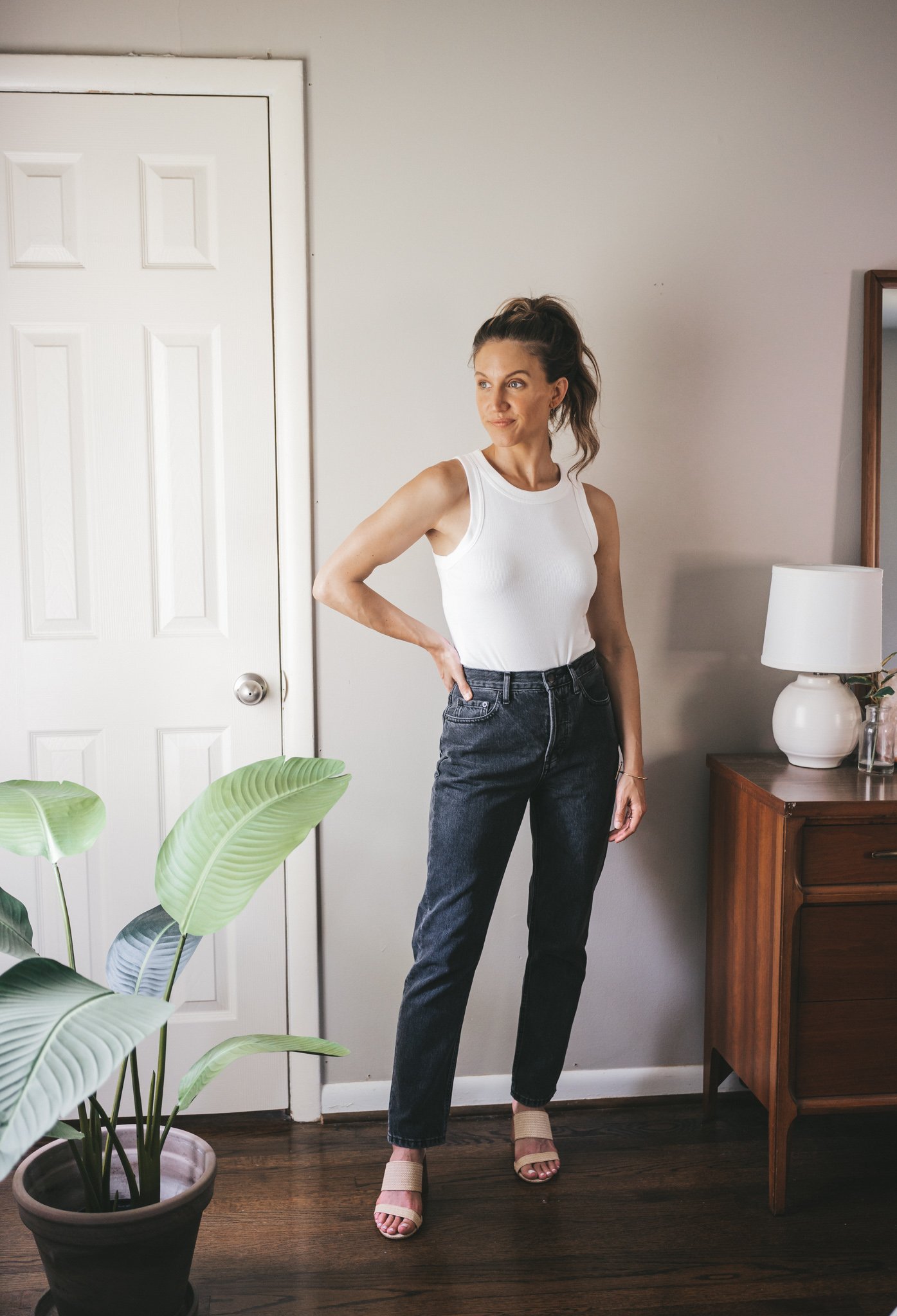 ashley wearing a white tank, straight denim, and woven heeled sandals