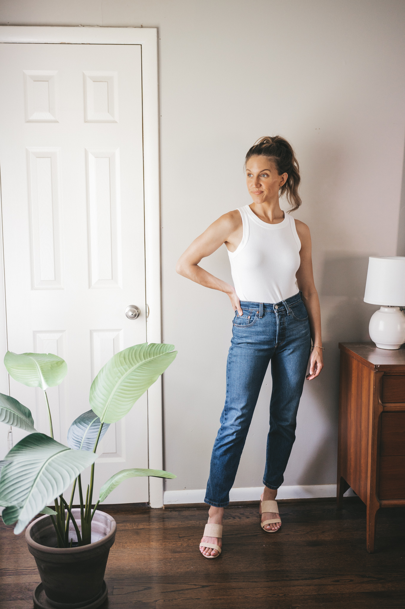 ashley wearing a white tank, straight denim, and woven heeled sandals