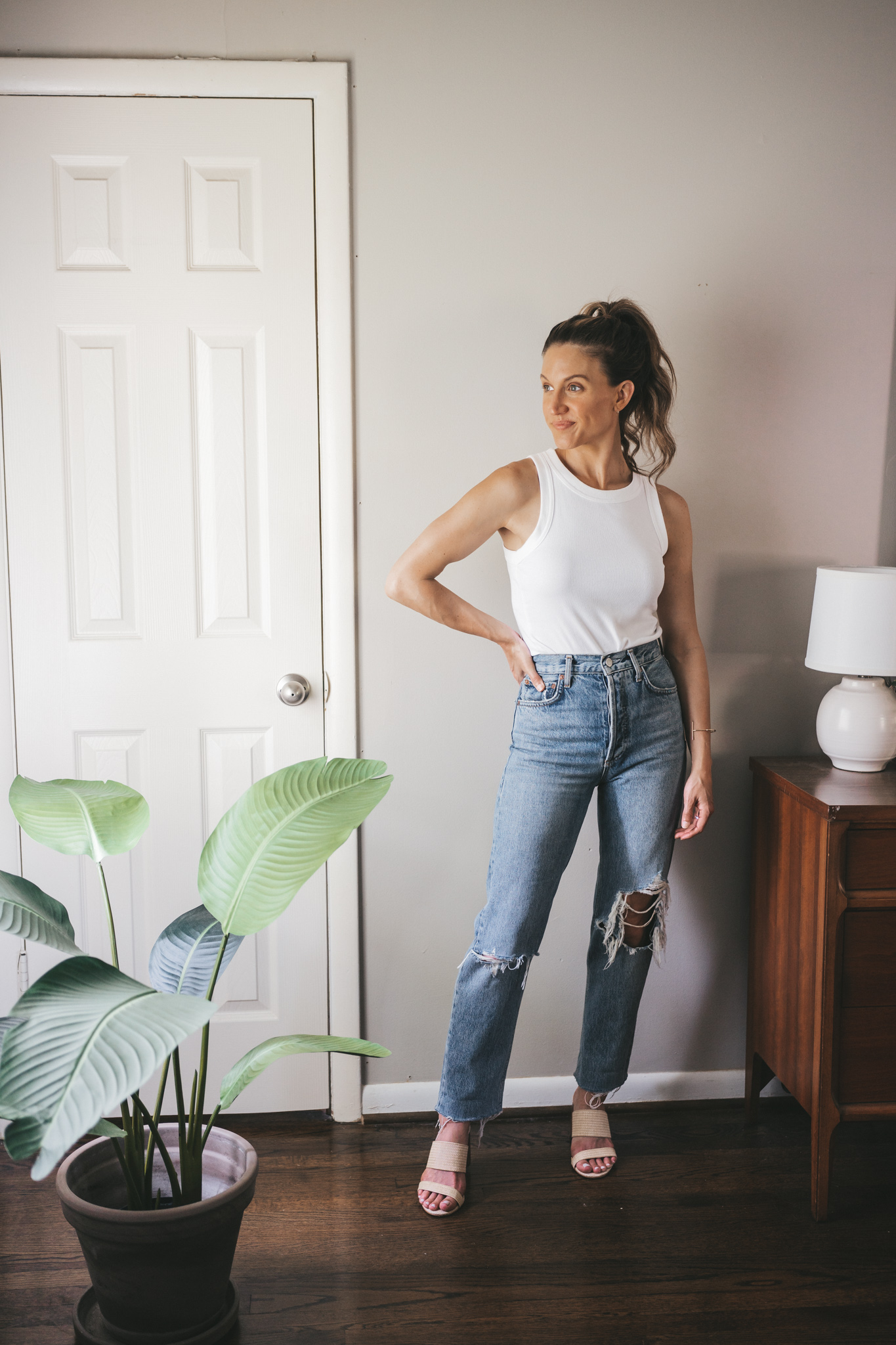ashley wearing a white tank, straight denim, and woven heeled sandals