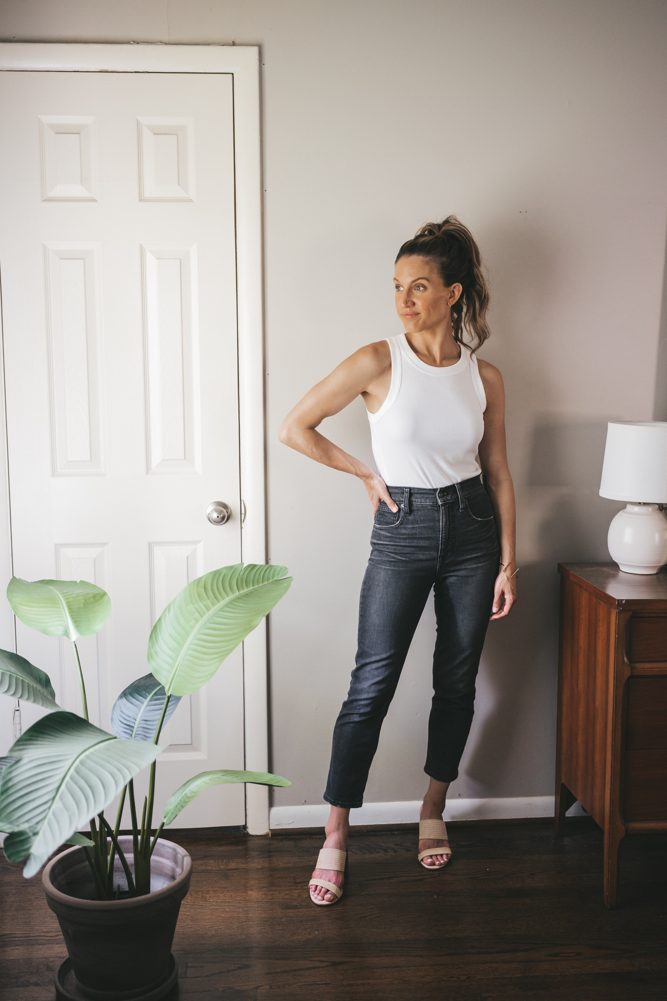 ashley wearing a white tank, straight denim, and woven heeled sandals