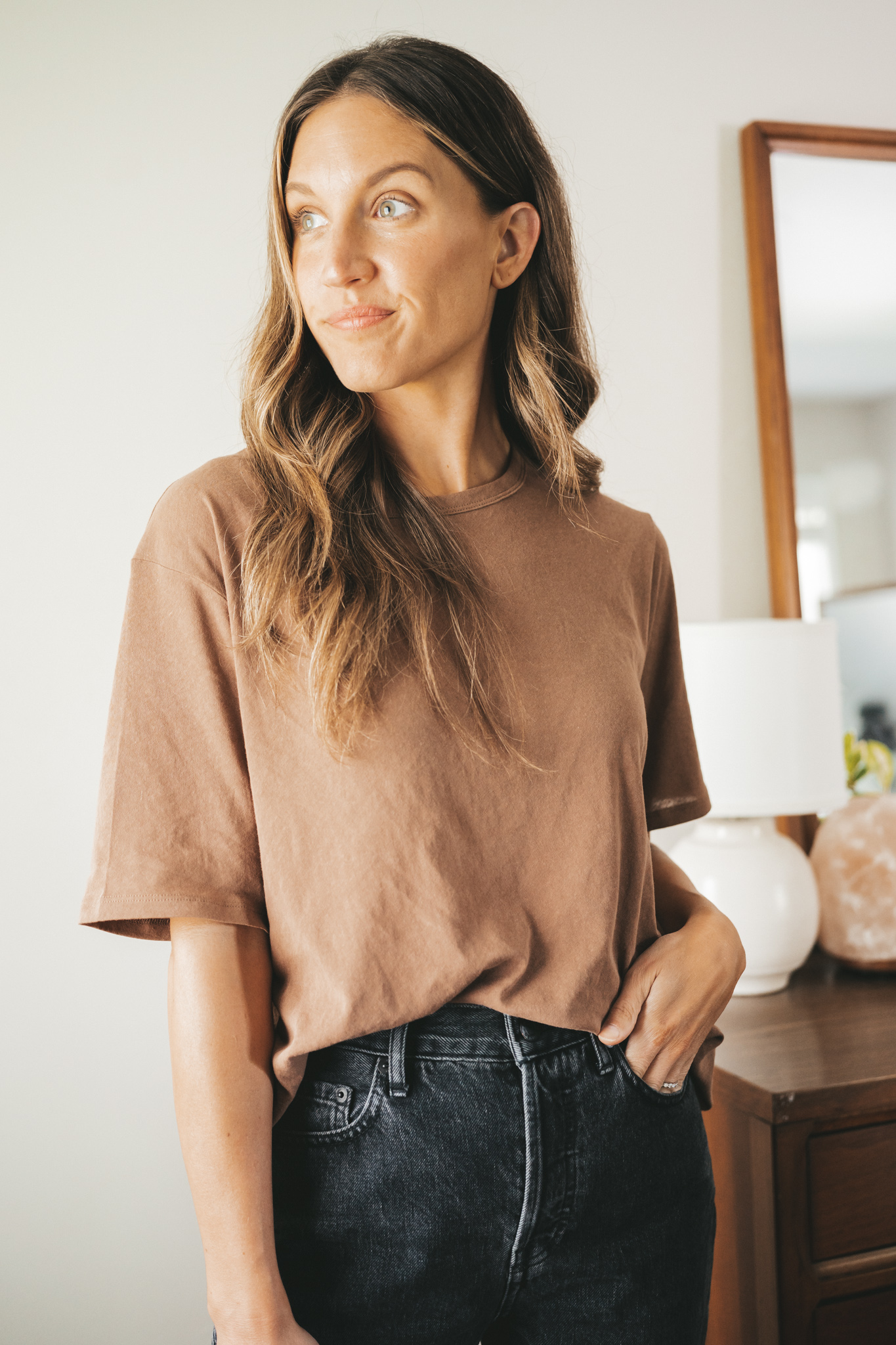ashley wearing a light brown t-shirt from Everlane, and black denim