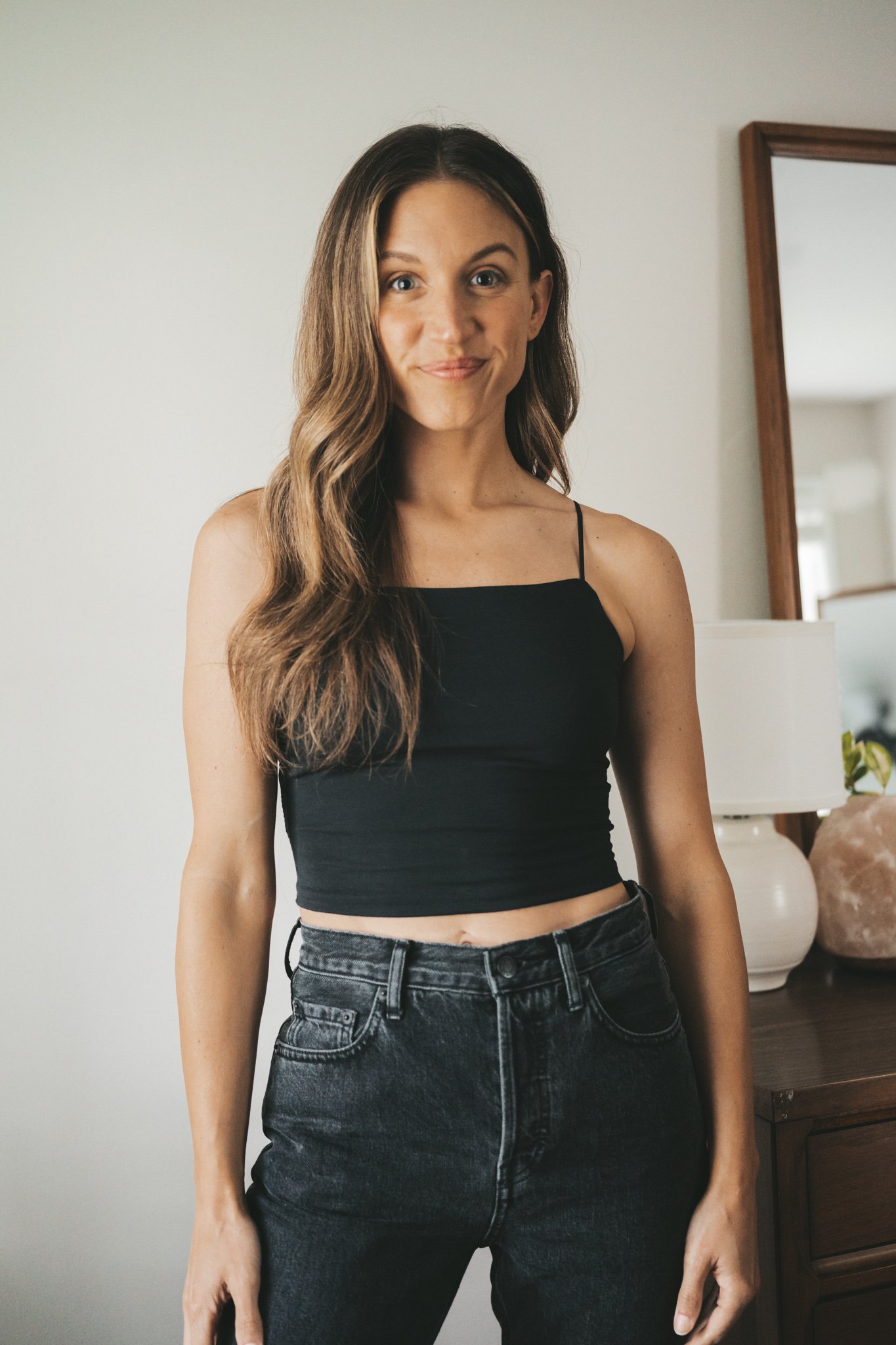 ashley wearing a cropped black cami from Everlane and black denim