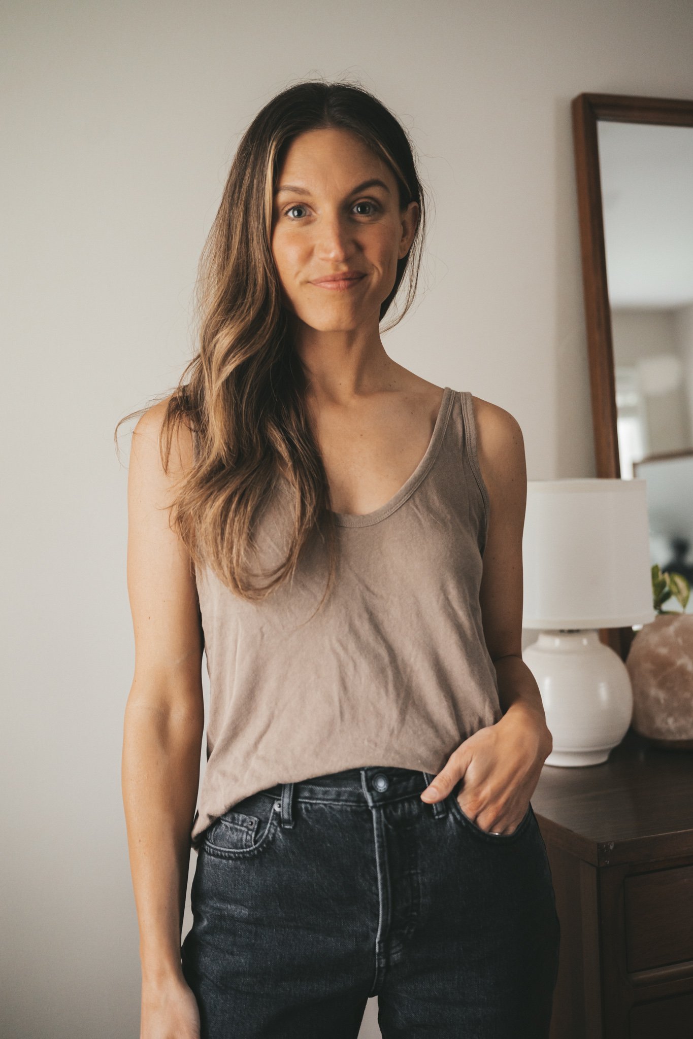 ashley wearing a taupe tank from Everlane and black denim