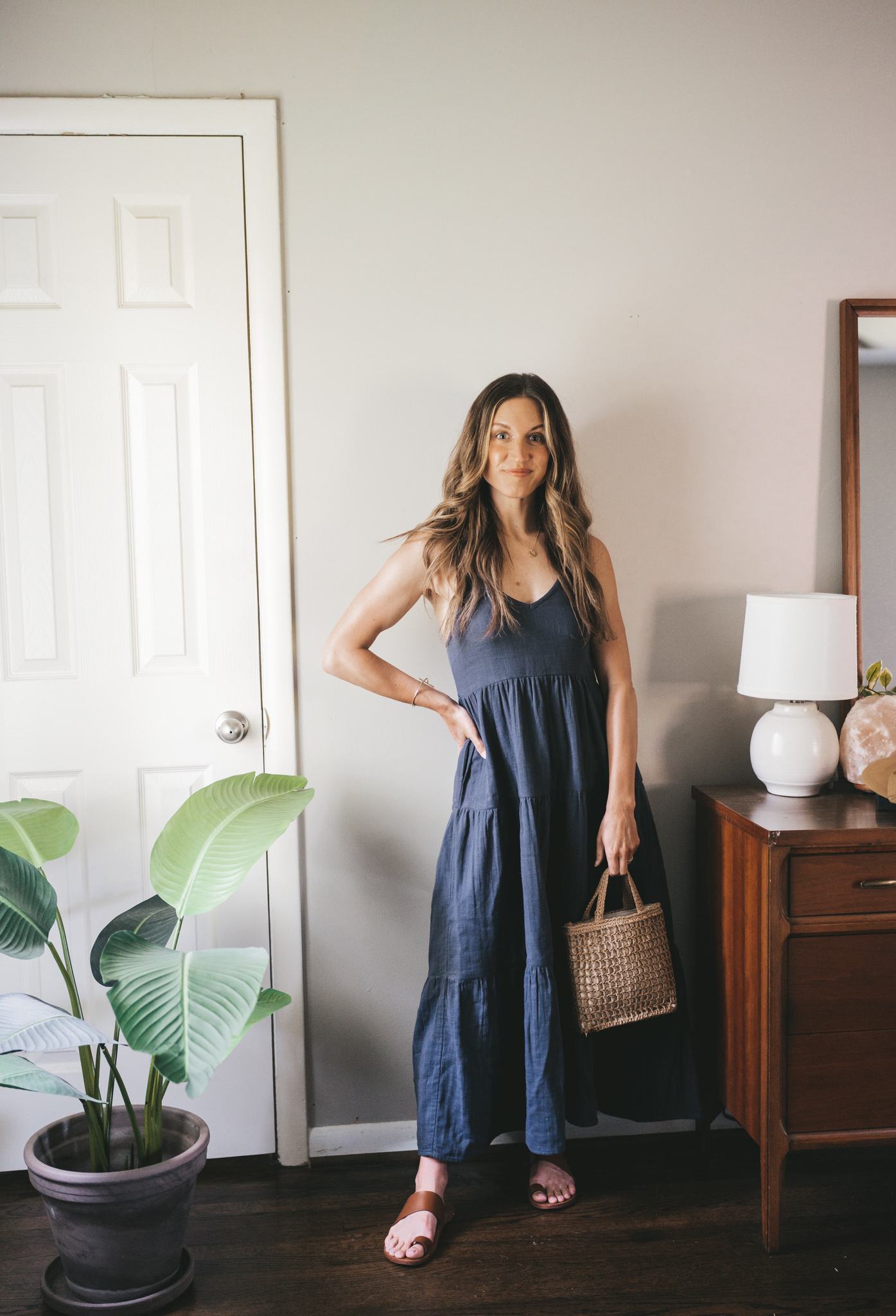 daily look with a washed black tiered maxi dress, brown leather sandals, and a straw bag