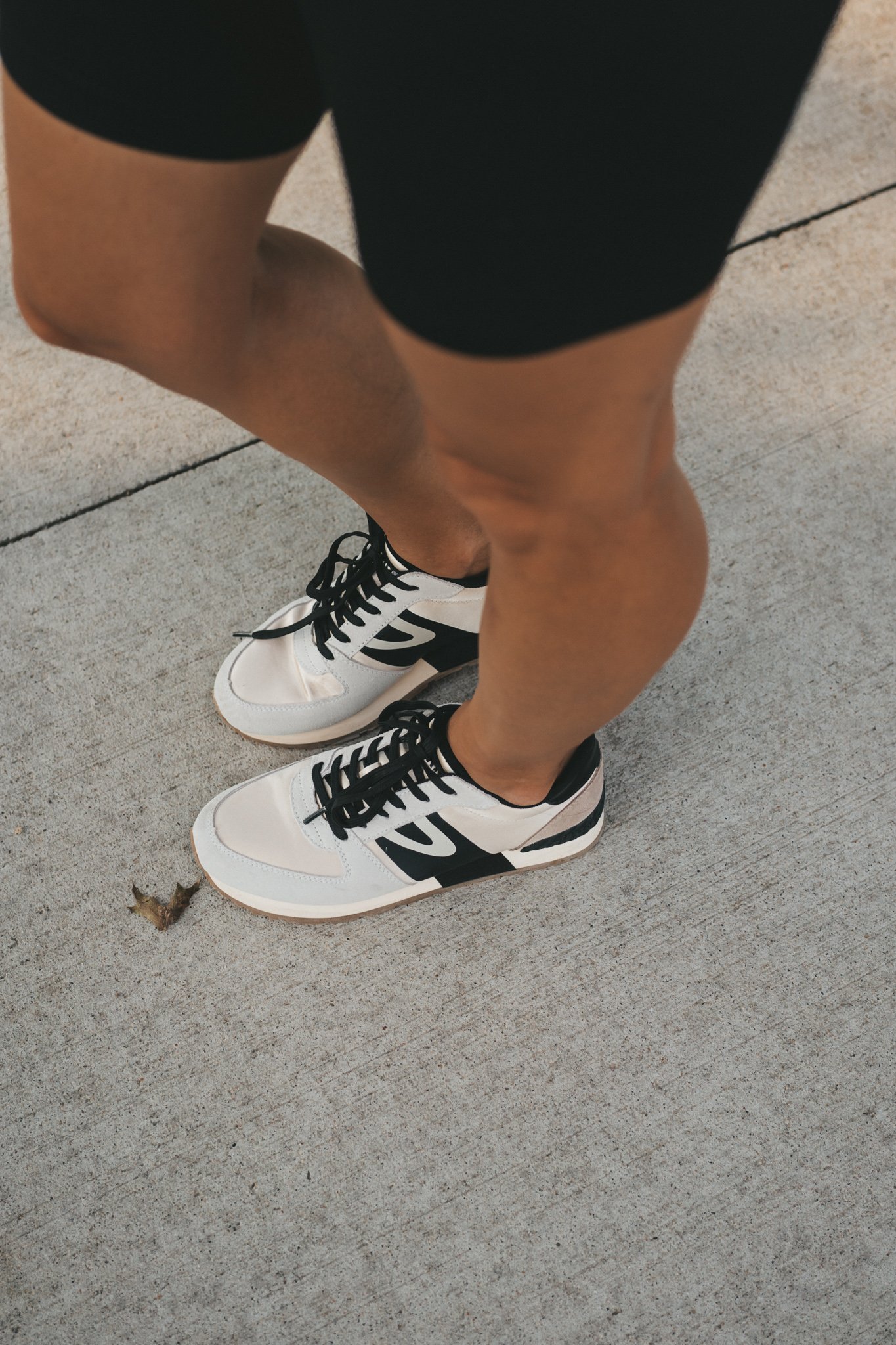 a close up of the a pair of gray, ivory, and black Tretorn sneakers 