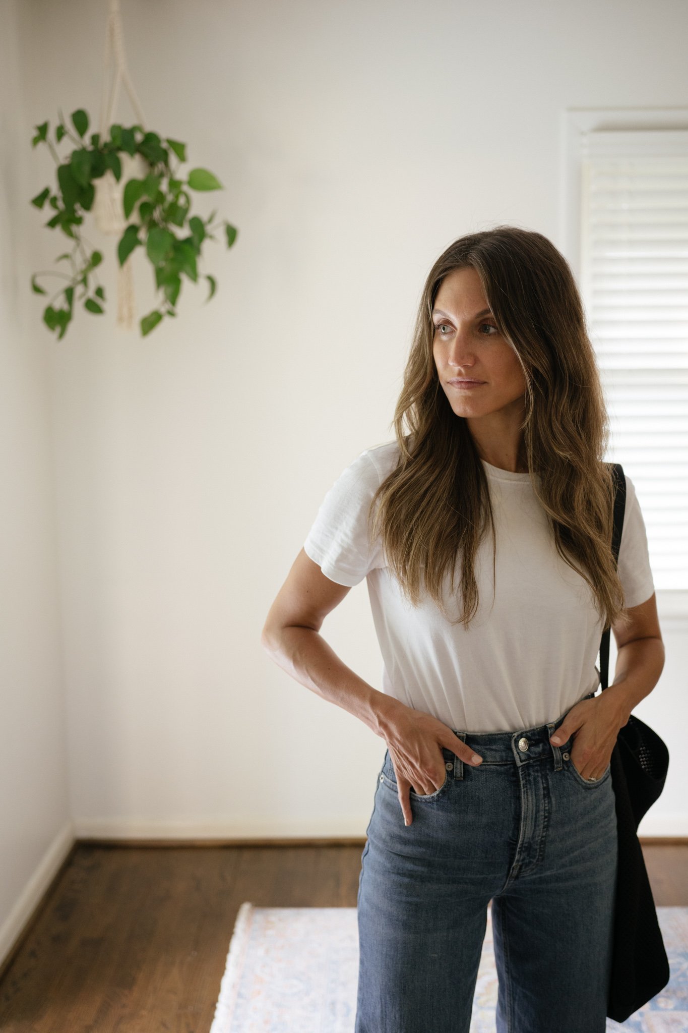 minimalist outfit with a white tee, denim, and a black tote bag