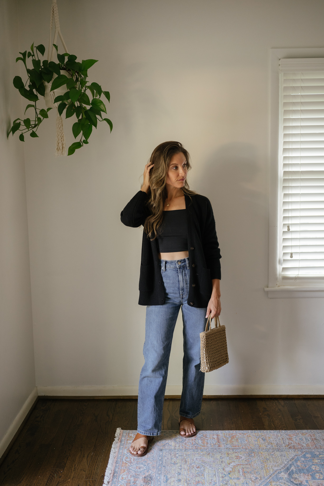 outfit idea for Seattle in the summer with a black cropped tank, black cardigan, straight denim, brown leather toe ring sandals, and a woven handbag