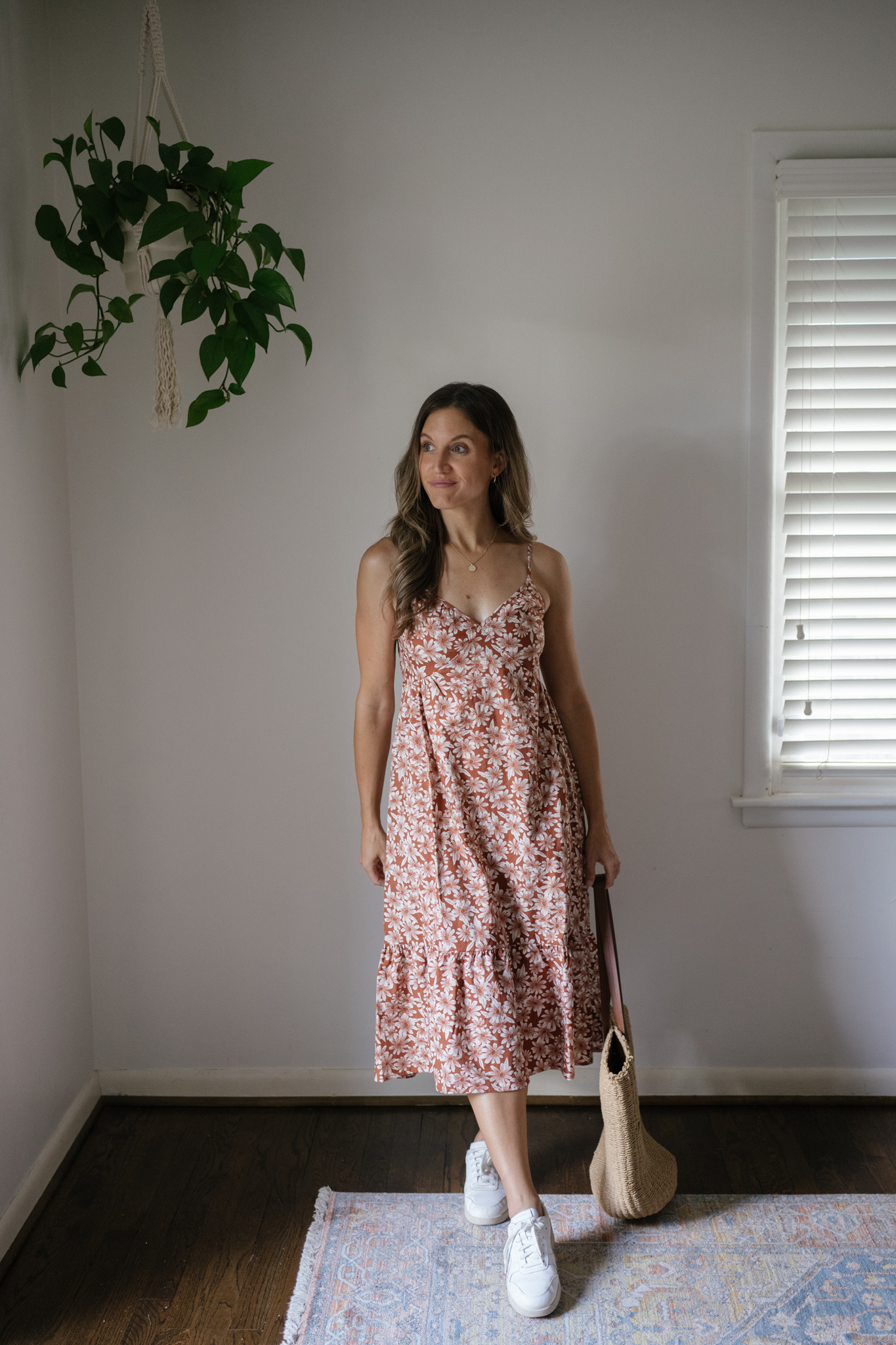outfit idea for Seattle in the summer with a dark orange floral midi dress, white sneakers, and a woven tote bag