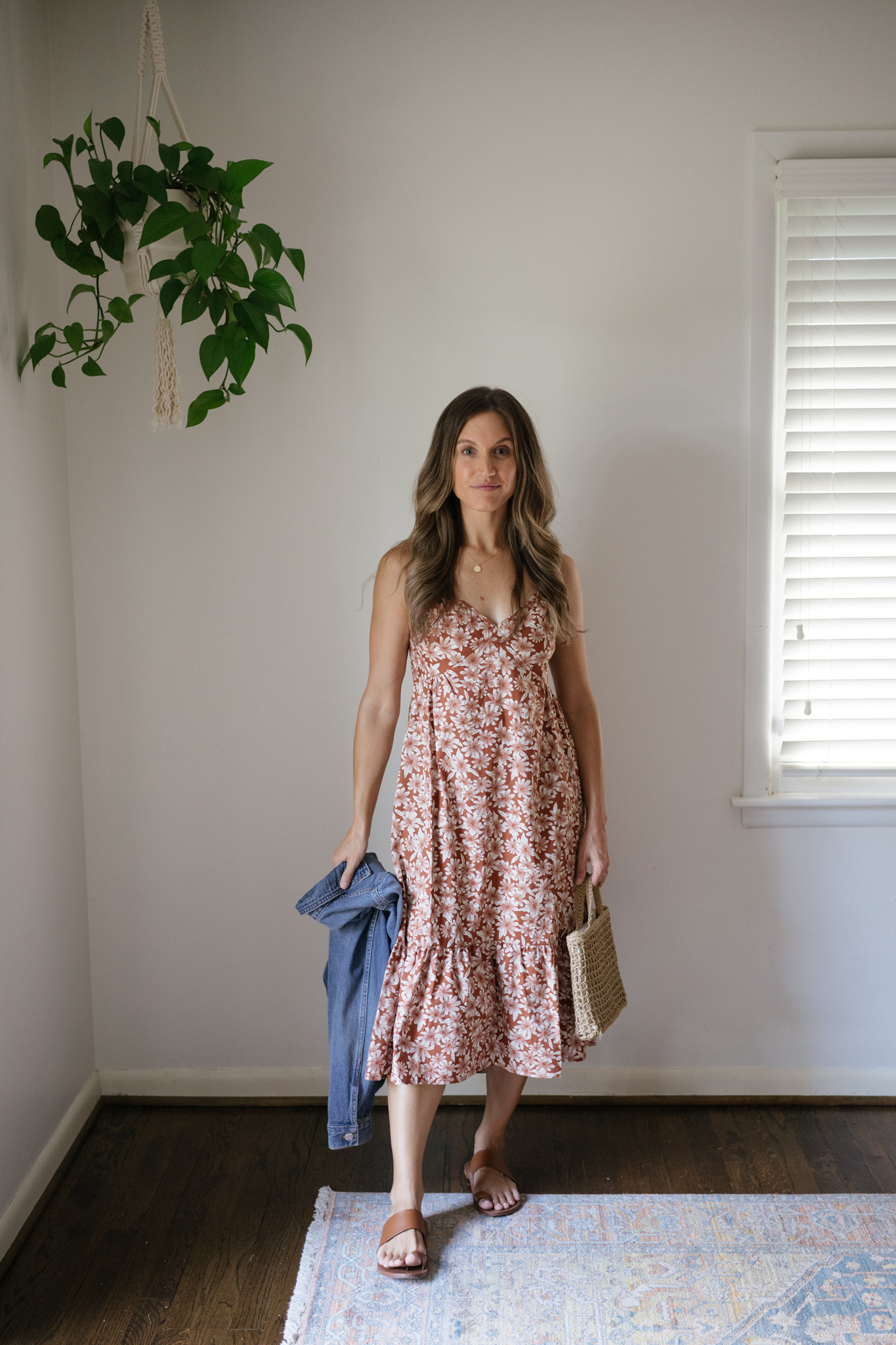 outfit idea for Seattle in the summer with a dark orange floral spaghetti strap midi dress, brown leather toe ring sandals, and a denim jacket