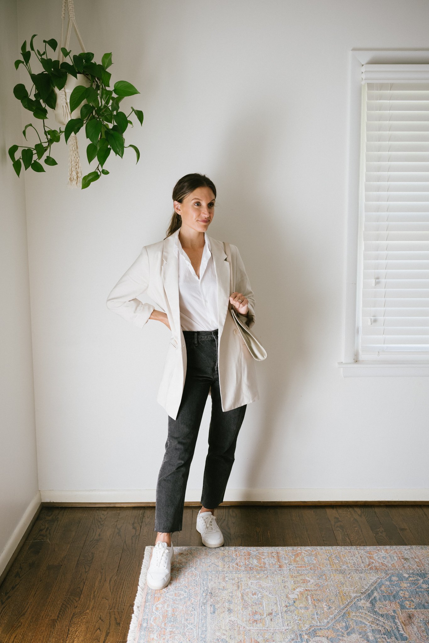 a white button down outfit with a beige blazer, washed black denim, and sneakers