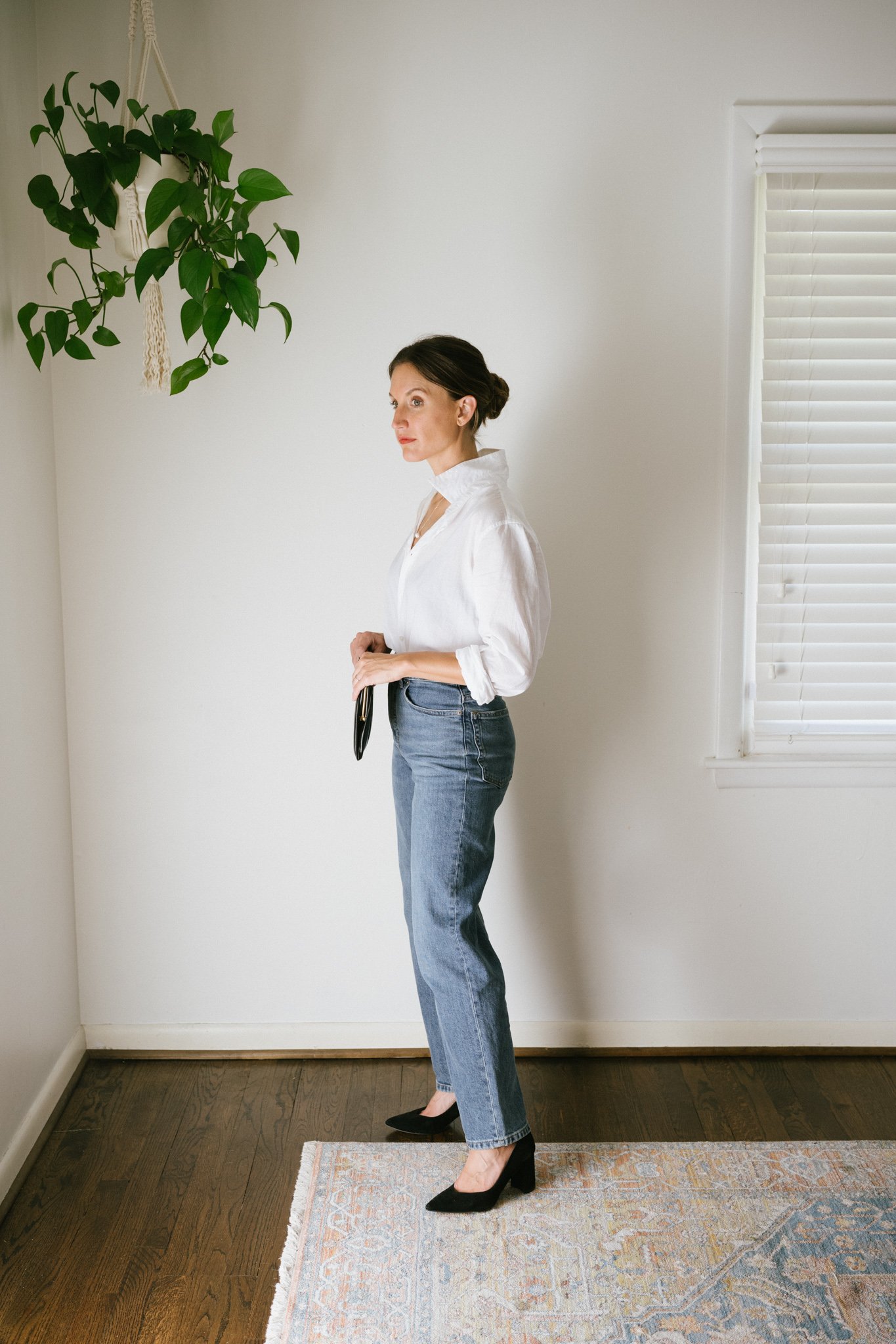 a white button down outfit with straight leg denim, and black block heel pumps