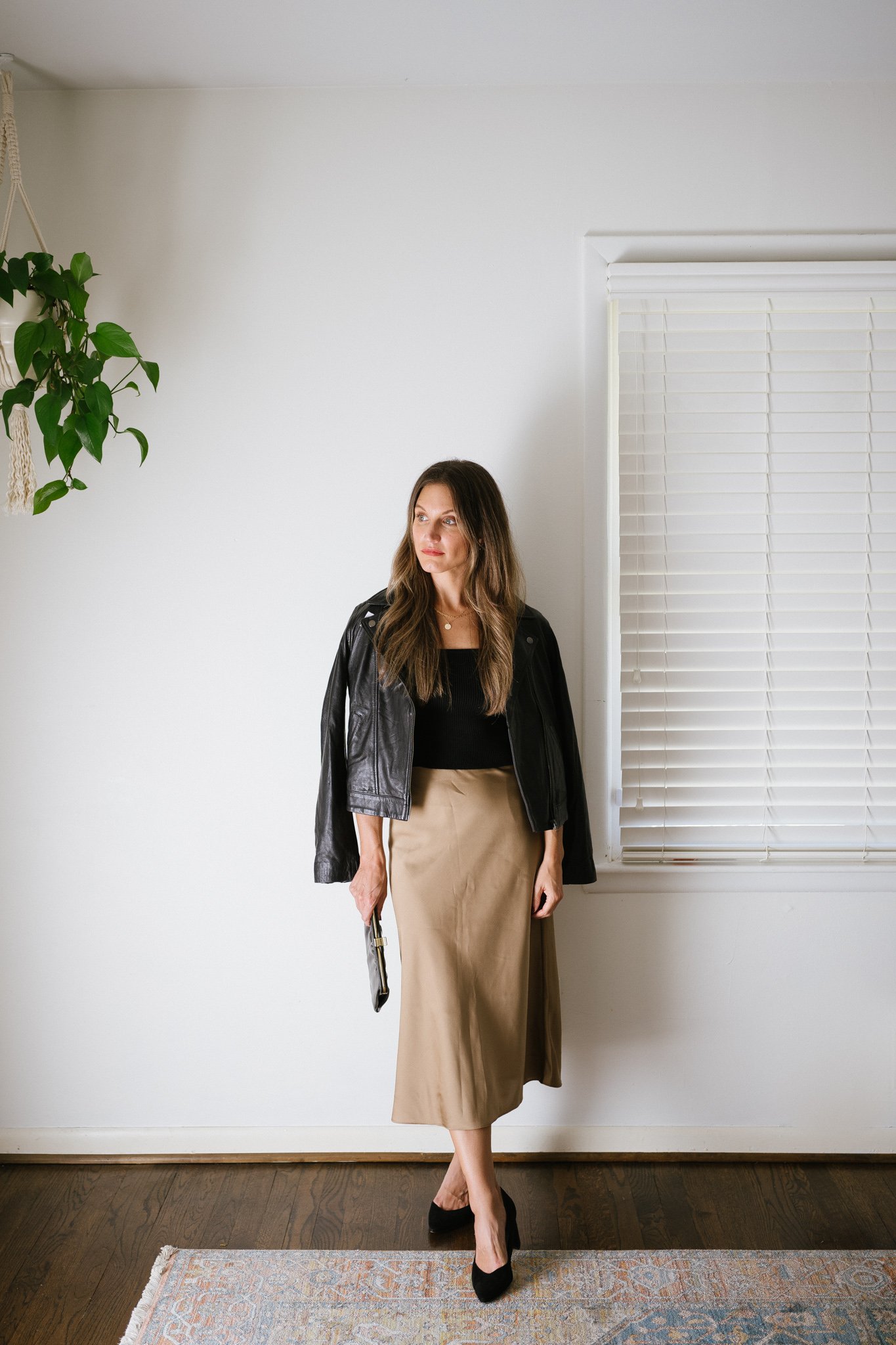 fall date night outfit with a sweater tank, leather jacket, slip skirt and black pumps