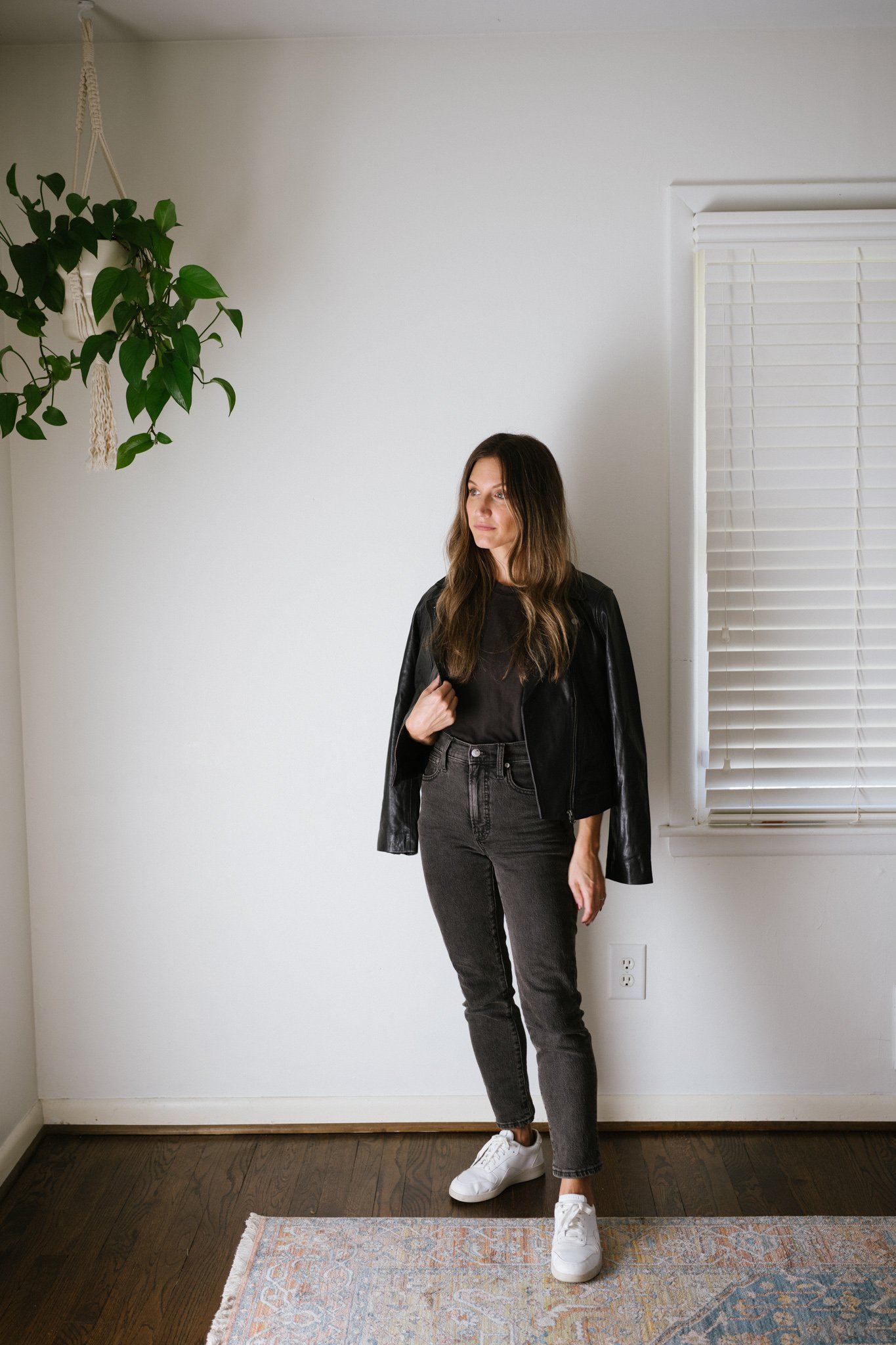 ashley wearing a black tee, black leather jacket, black denim, and white sneakers