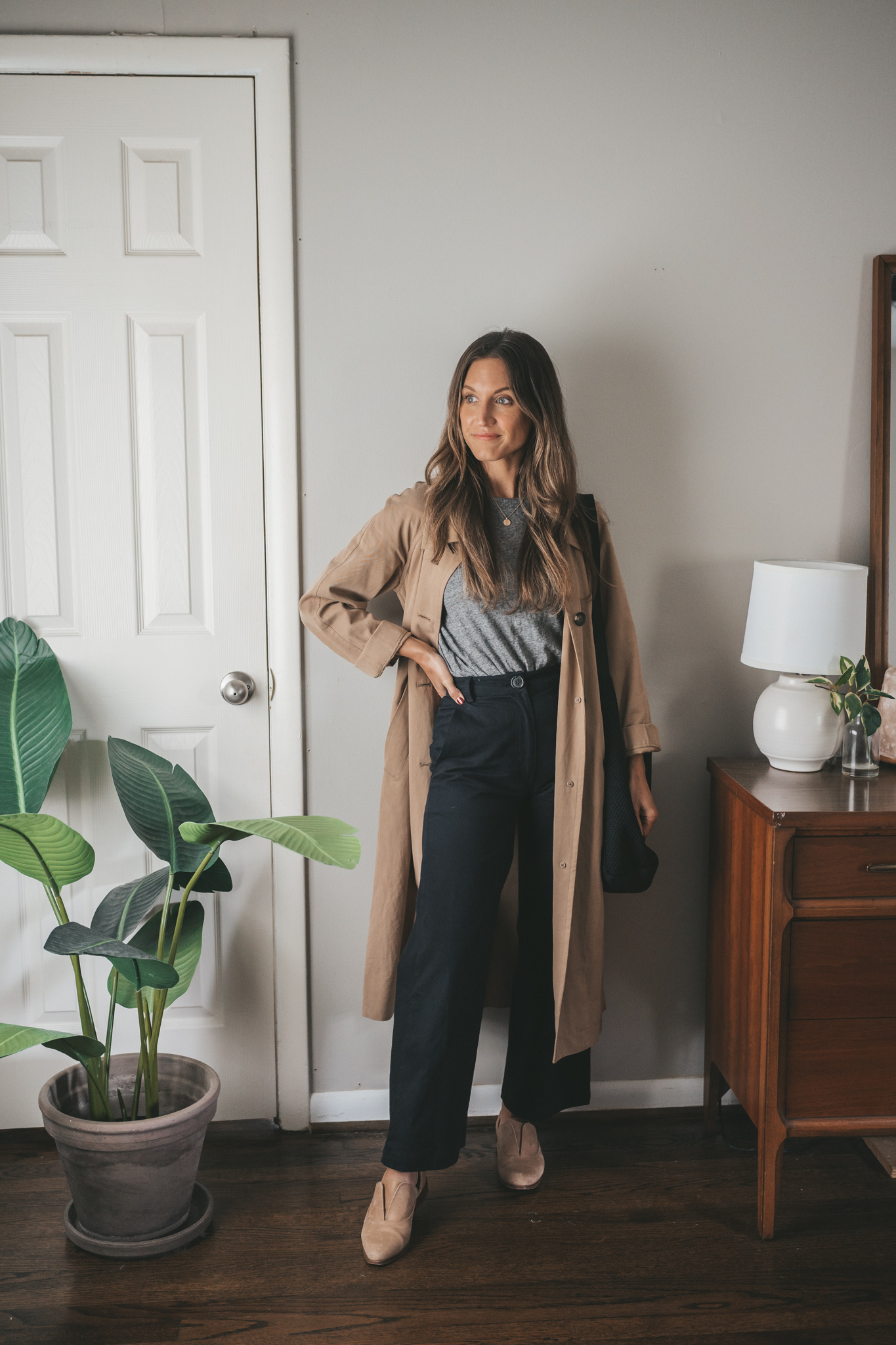 a fall outfit with a gray tee, tan trench coat, black wide leg crop pants, and nude oxfords
