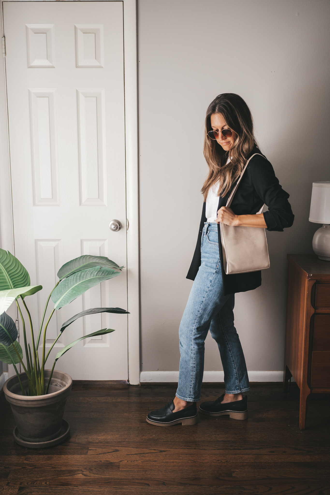 casual chic outfit idea with a white tee, black blazer, mid-wash denim, and chunky loafers