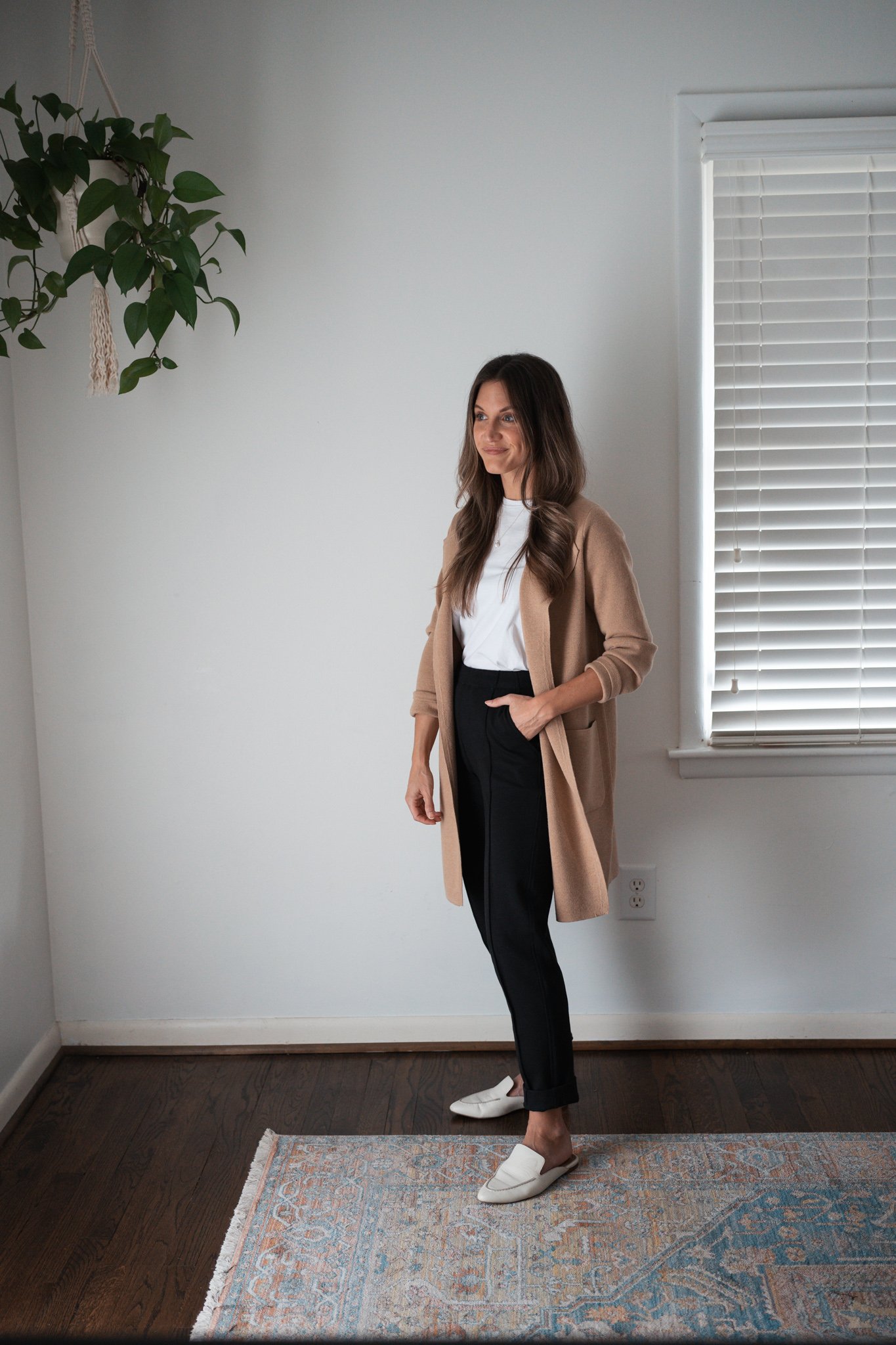 ashley wearing a white tee, tan sweater blazer, black pants, and white mules